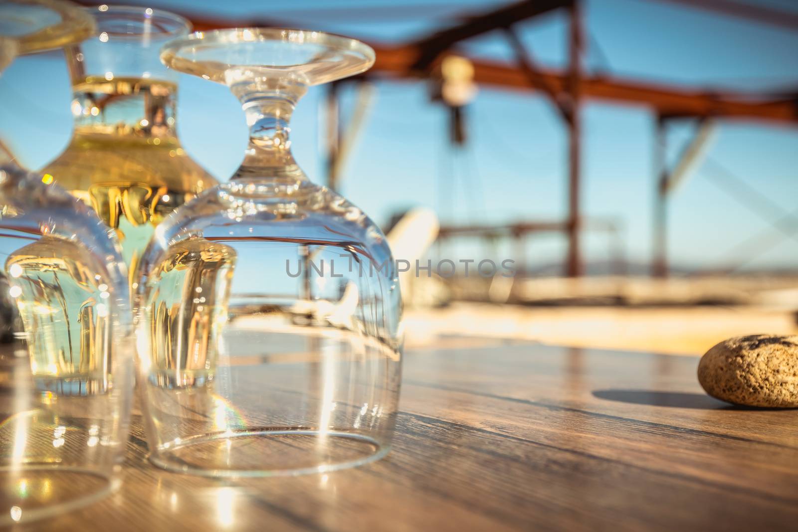 carafe of white wine with wine glasses on a table by the sea