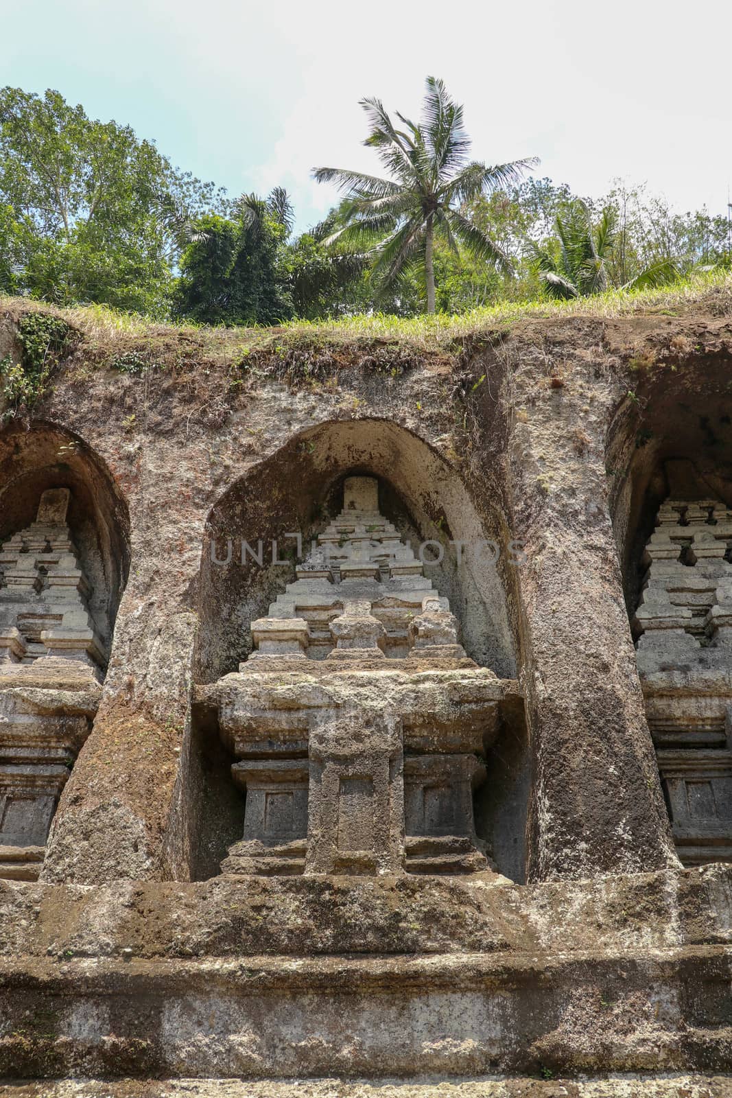 Candi (shrines) carved into a rock in a valley by the Pakerisan River. Gunung Kawi is an 11th-century temple and funerary complex in Tampaksiring northeast of Ubud in Bali, Indonesia.