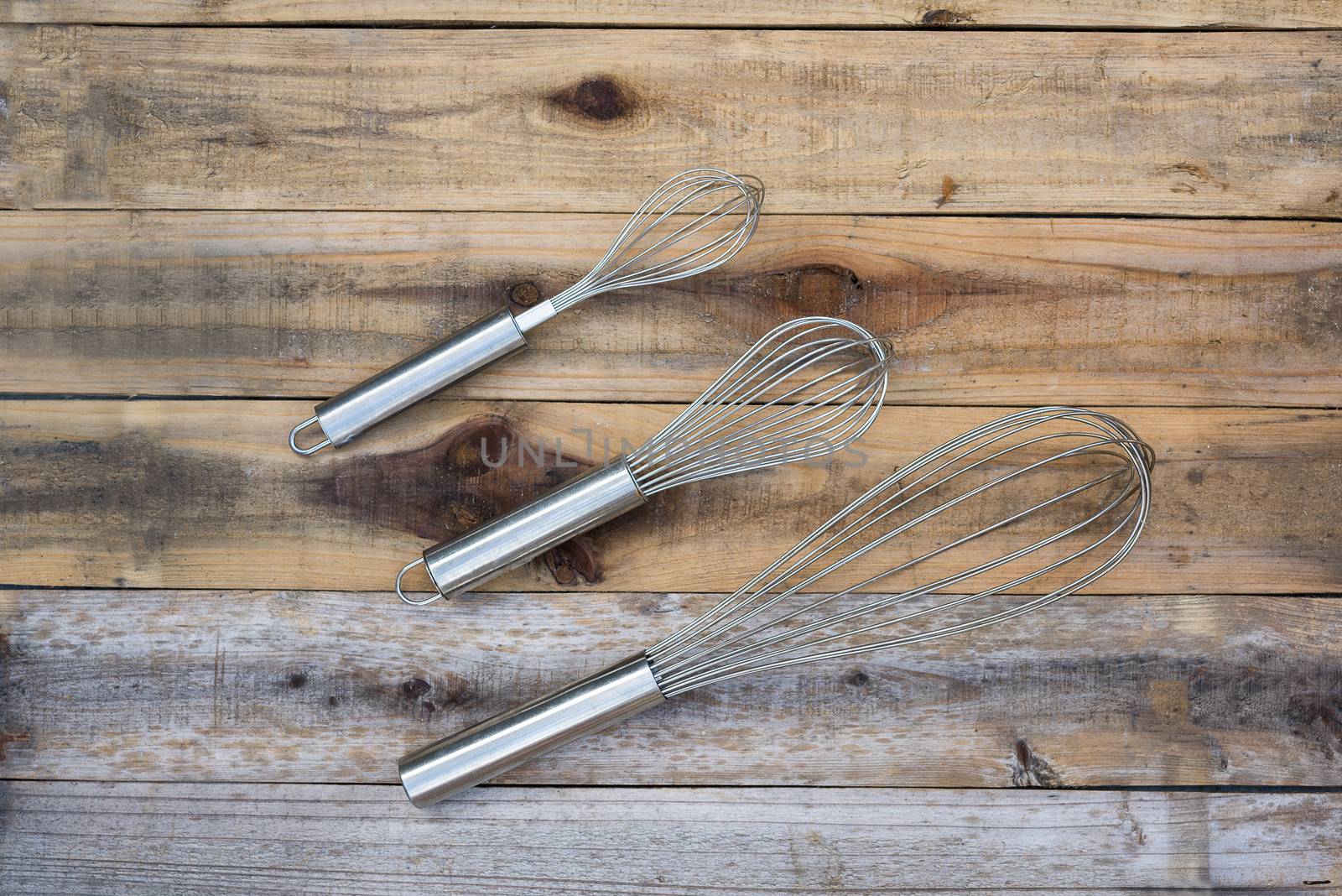 3 whisk different size on wood table