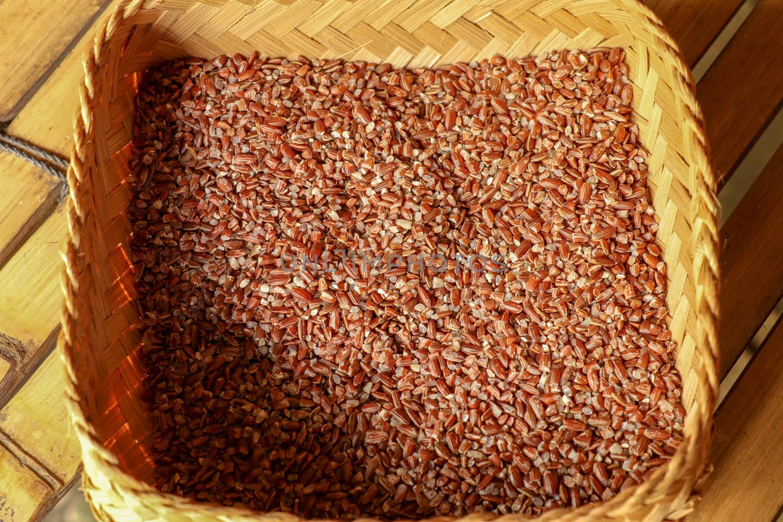 Wicker robe made of bamboo strips filled with fresh natural organic rice. Close up of natural process of rice drying on factory in Bali. Dried rice seeds.