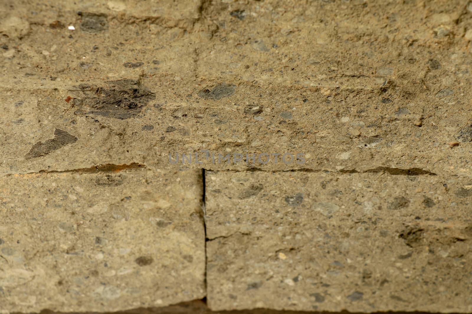 Stone wall made of roughly worked stones of natural color. Selective focus. Detail of a rock-faced stone wall made with blocks. Typical detail of an old wall made of hand-carved stones eroded by time.