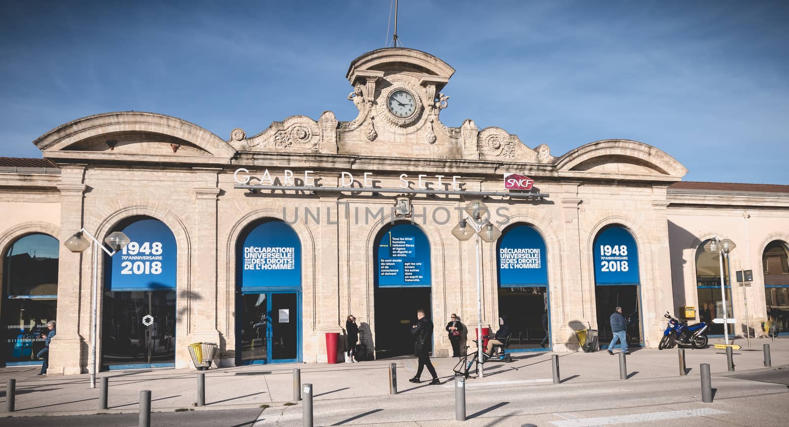 People are waiting or walking in front of the SNCF train station by AtlanticEUROSTOXX