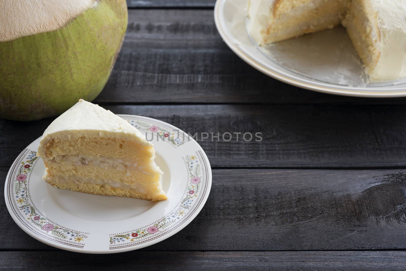 Coconut cream cake with coconut fruit on wood bakcground