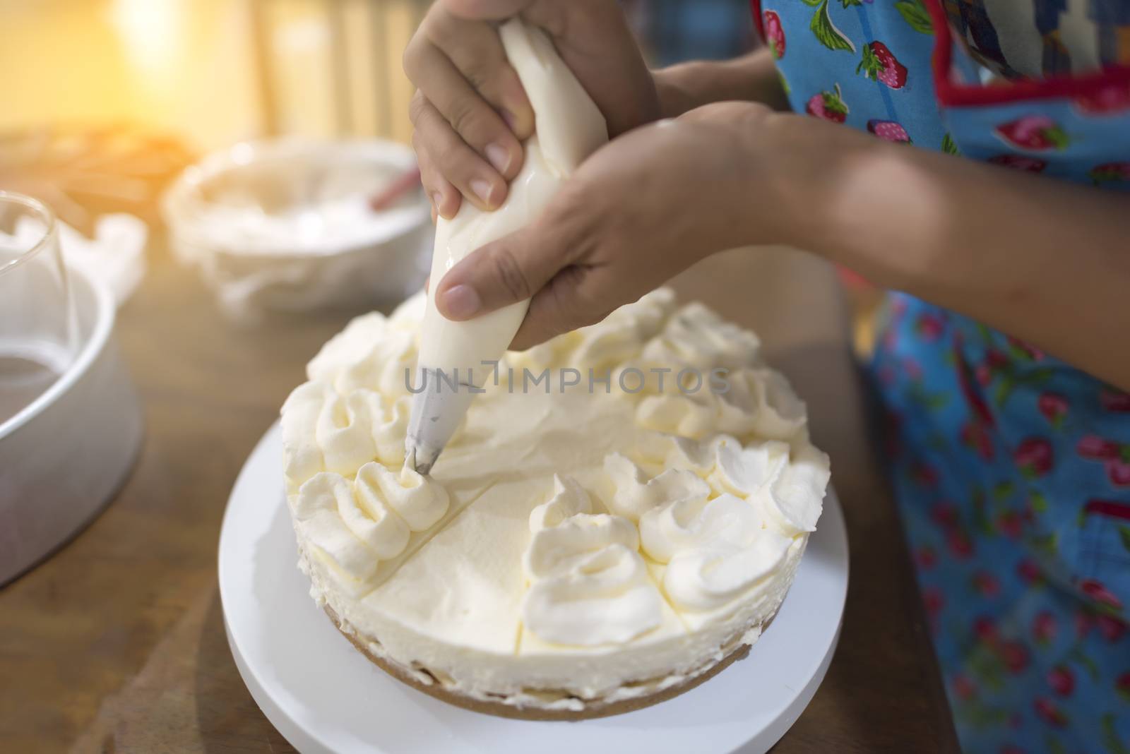 Women hand decorating with a pastry bag with cream