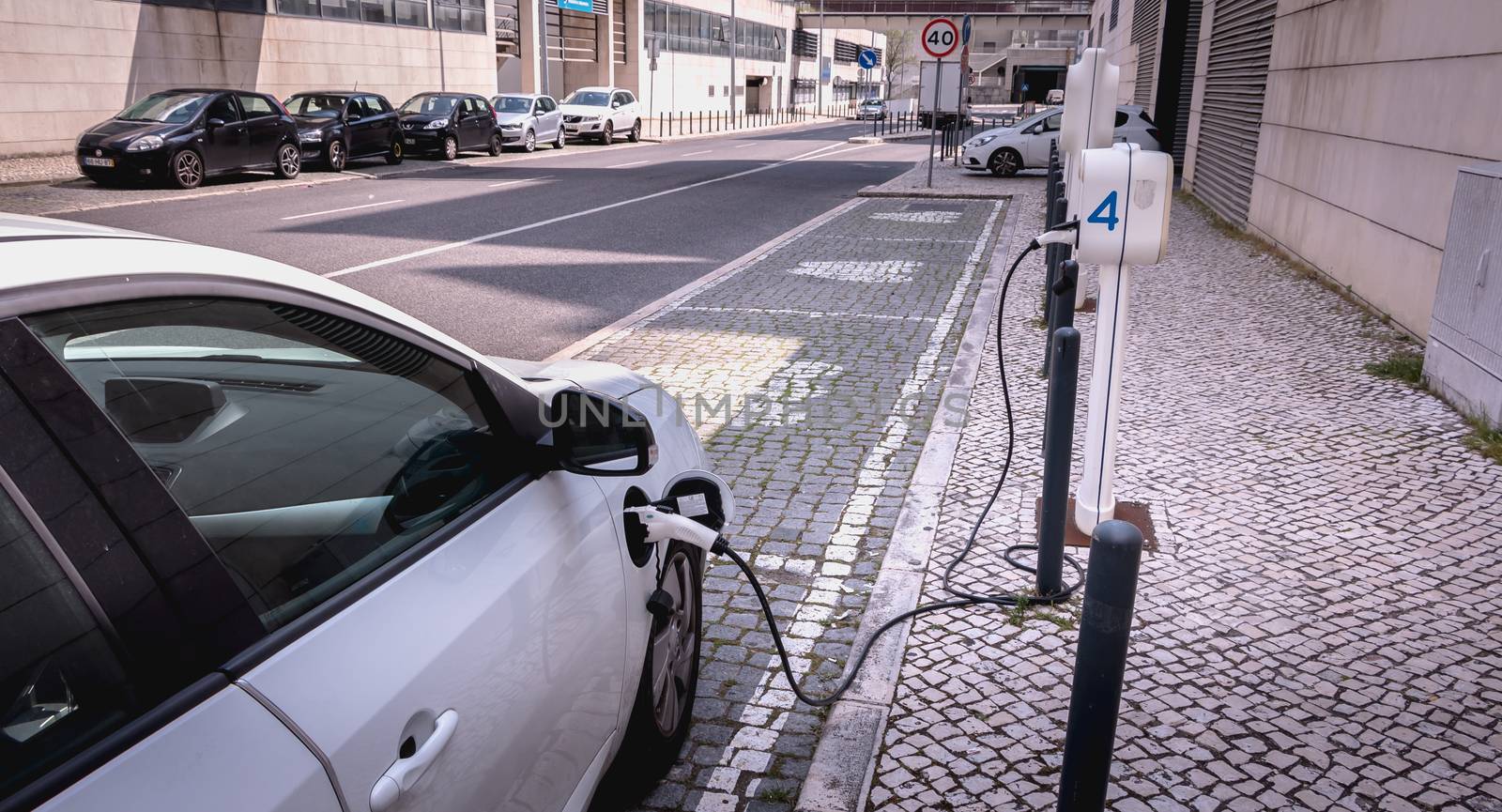 Lisbon, Portugal - May 7, 2018: Electric car in charge in a reserved parking lot of the Nations Park district on a spring day