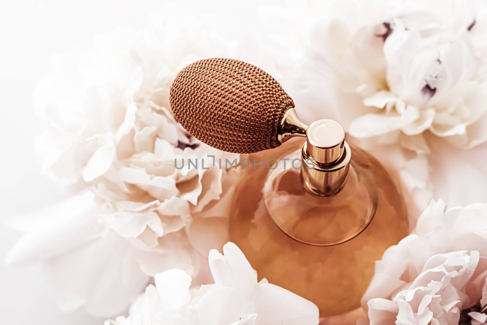 Fragrance bottle as vintage perfume product on background of peony flowers, parfum ad and beauty branding design