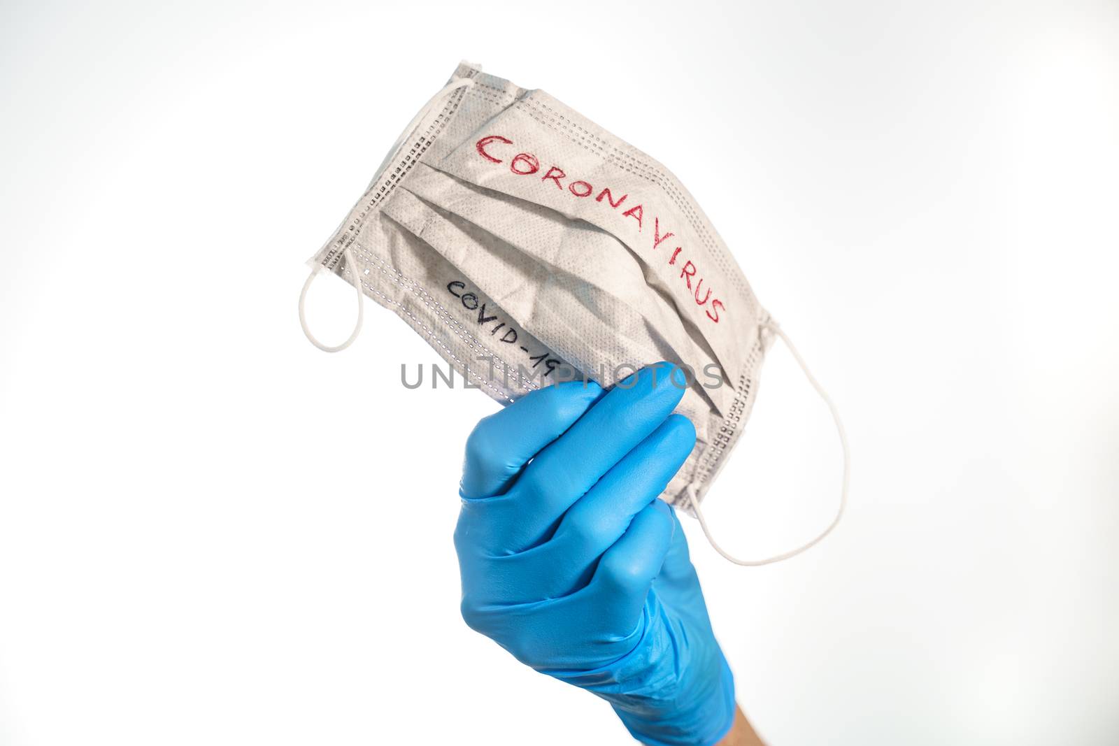 Hand with a face mask with the word coronavirus isolated on white by tanaonte