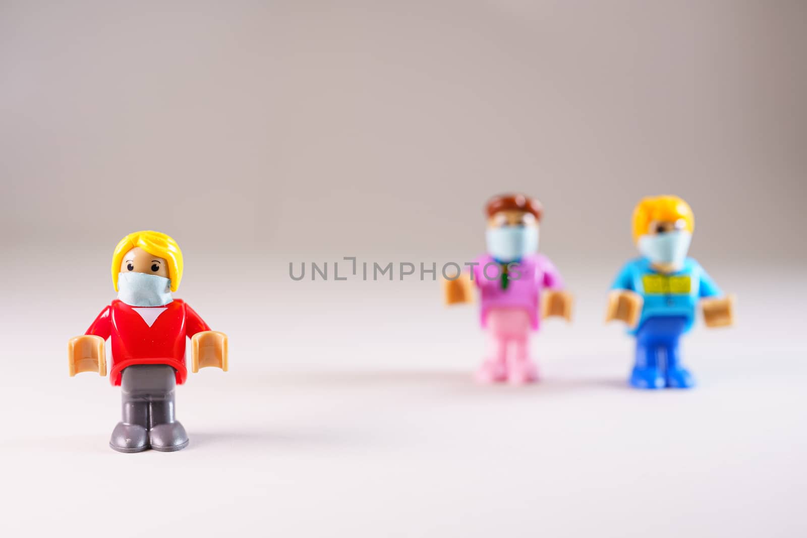 Small toy figure with face mask isolated from group by tanaonte