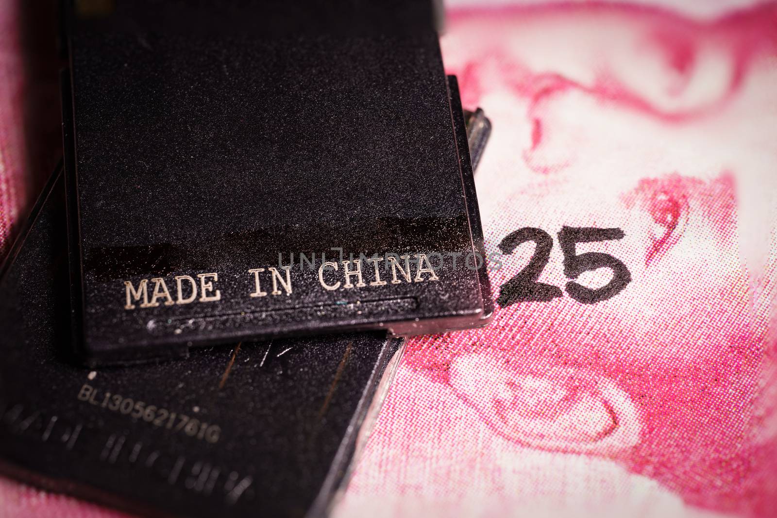 Made in china text written on a piece of plastic over a yuan bill. by tanaonte