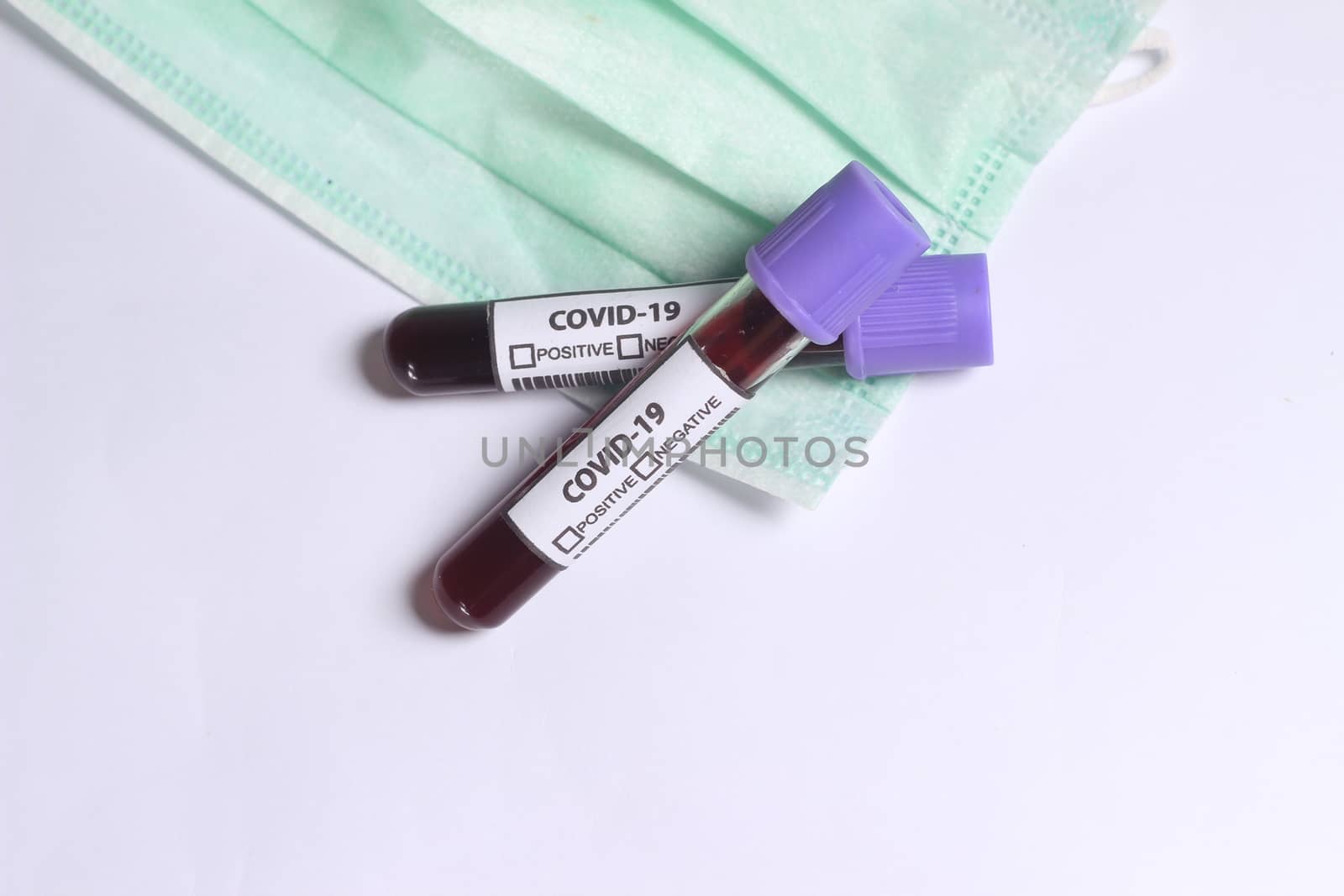 Simple Conceptual, Glass Blood Covid-19 Test tube, above N95 Surgical Mask
