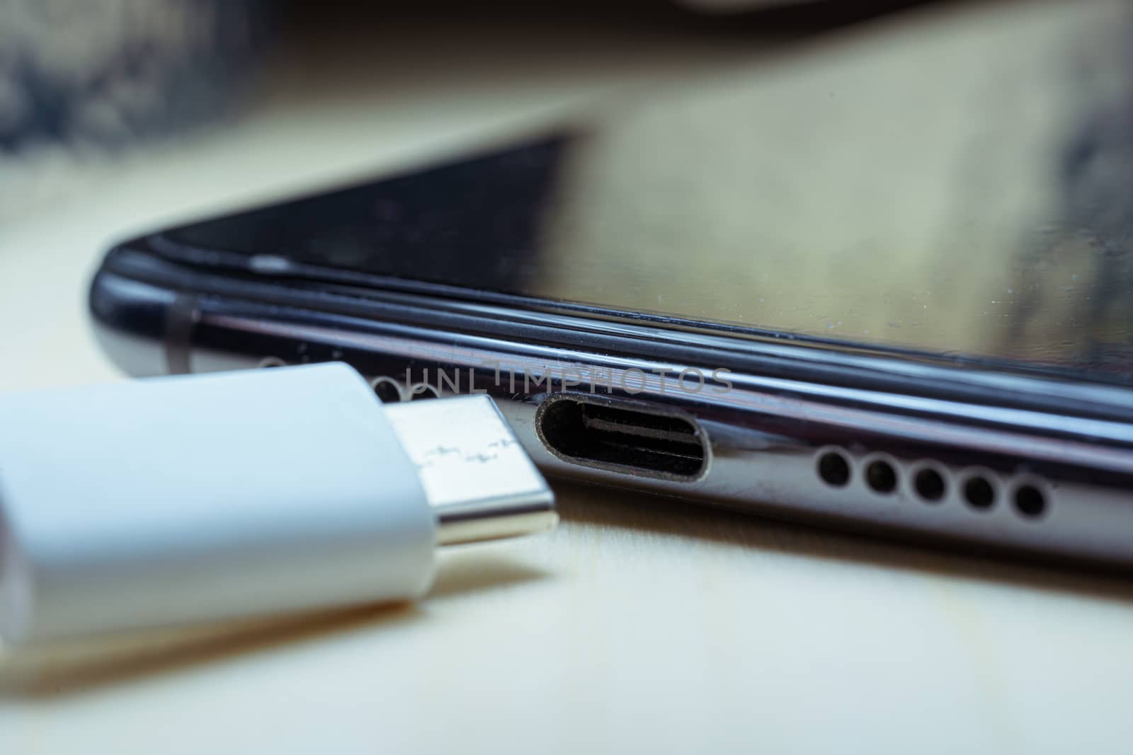 white USB Type C cable and USB-C port on smartphone. Macro shot. The EU will vote to force all smartphones to adopt USB-C as universal plug.