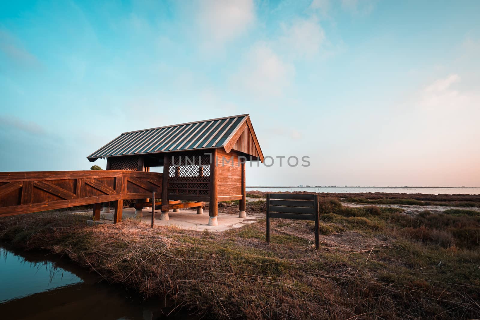 Wooden cabin or bird hut for bird watching in the Ebro river delta, Spain. Teal and orange style.