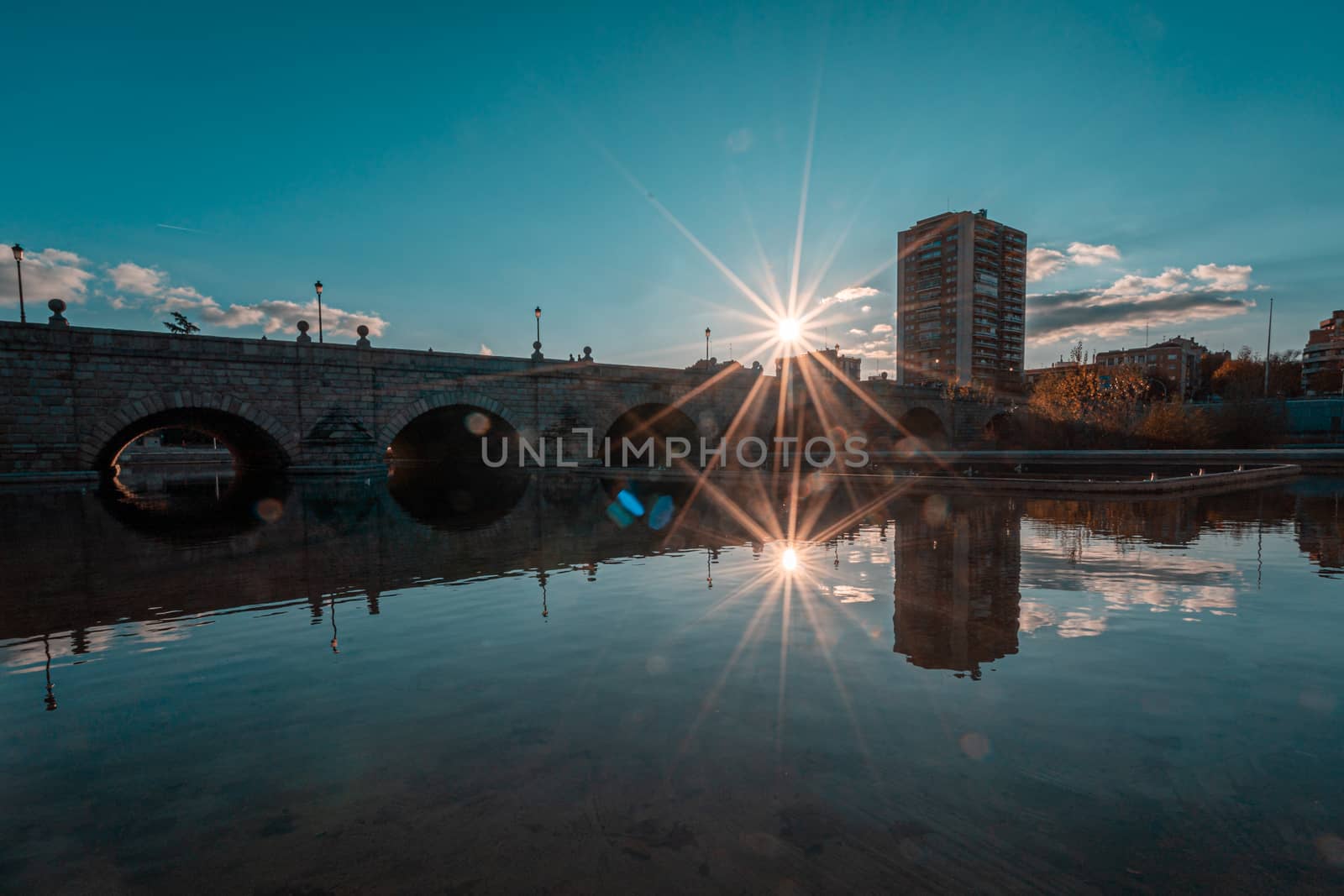 Puente de Segovia or Segovia Bridge reflected on river Manzanares in Madrid, Spain. Teal and orange graded.