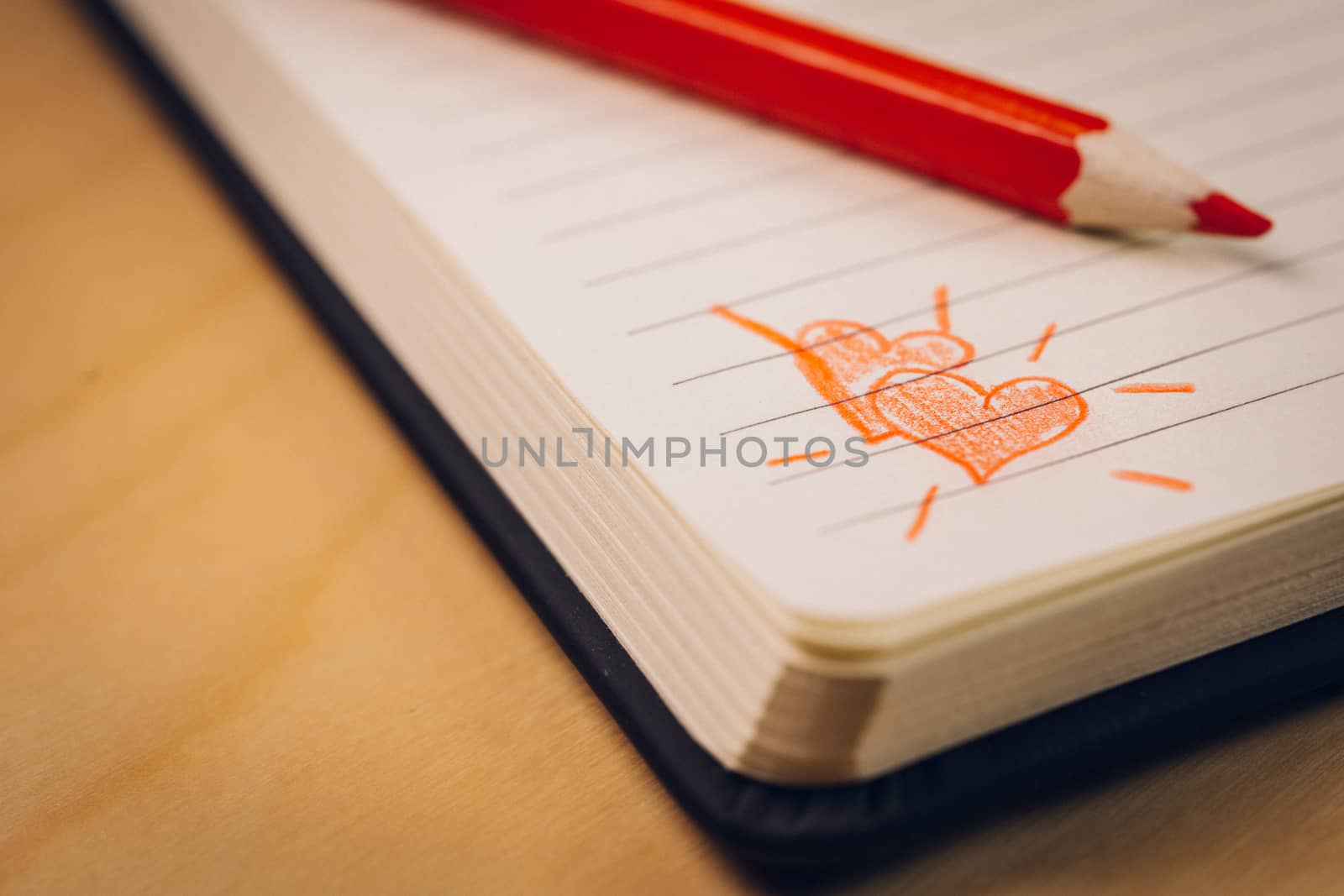 love hearts on notebook with red pen over a wooden table. Suitable for love, valentine, anniversary, couple and friendship concepts.