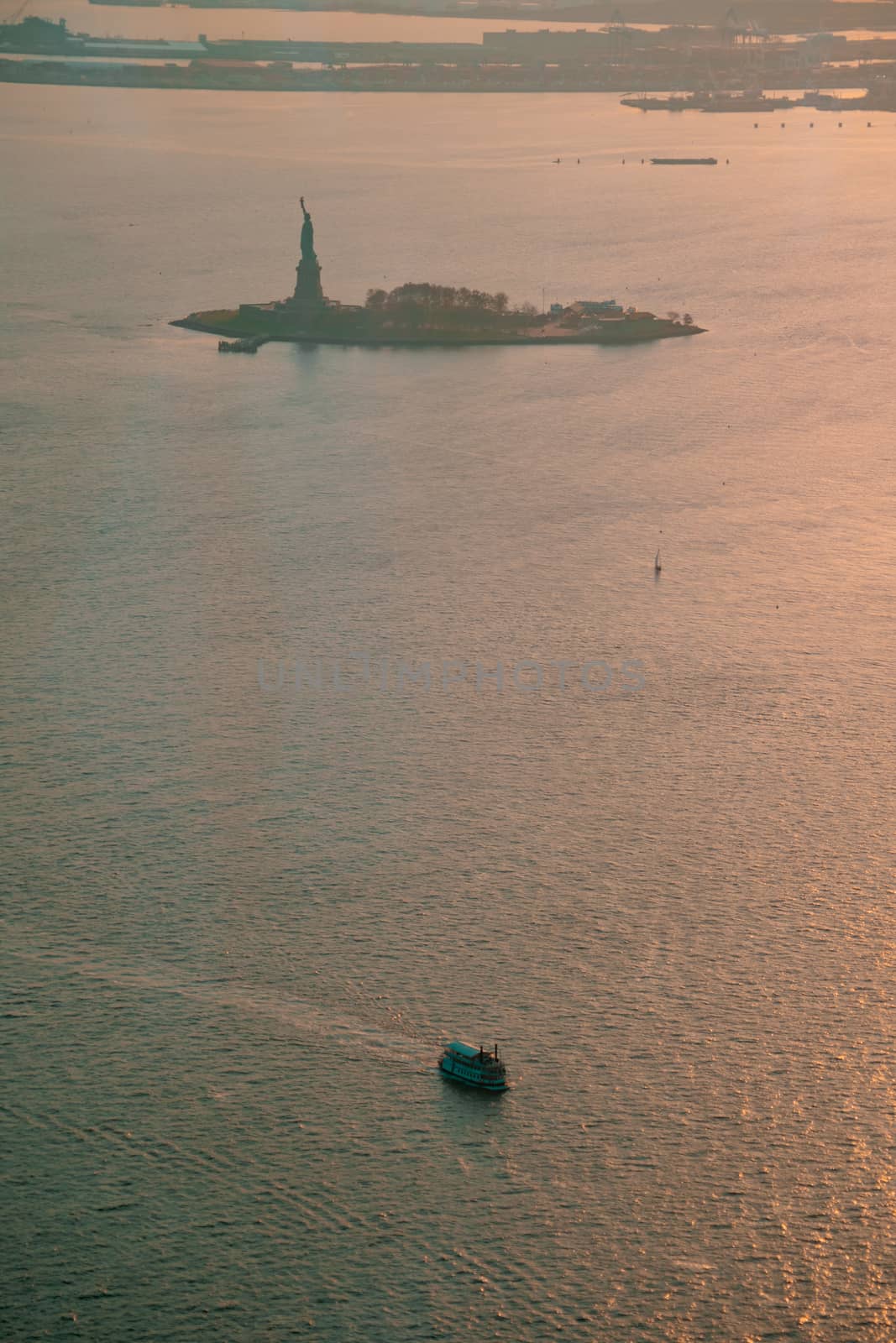Liberty island and Statue of Liberty aerial photo at sunset or golden hour. Teal and orange style.