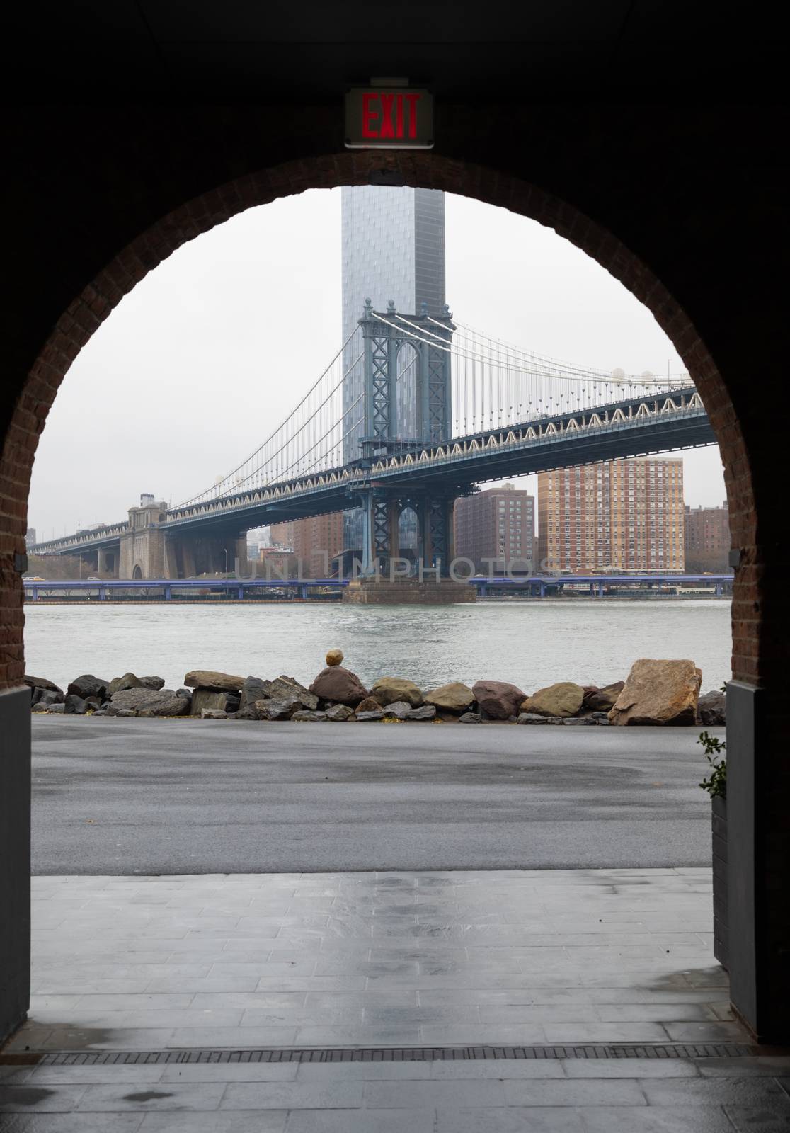 Pillar of Manhattan Bridge as seen from an brick arch gate in Dumbo district, Brooklyn