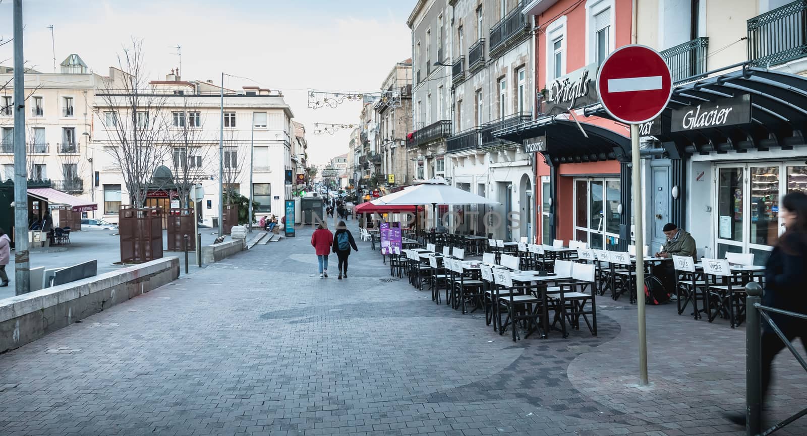 Sete, France - January 4, 2019: People walking in a shopping street in the historic city center on a winter day