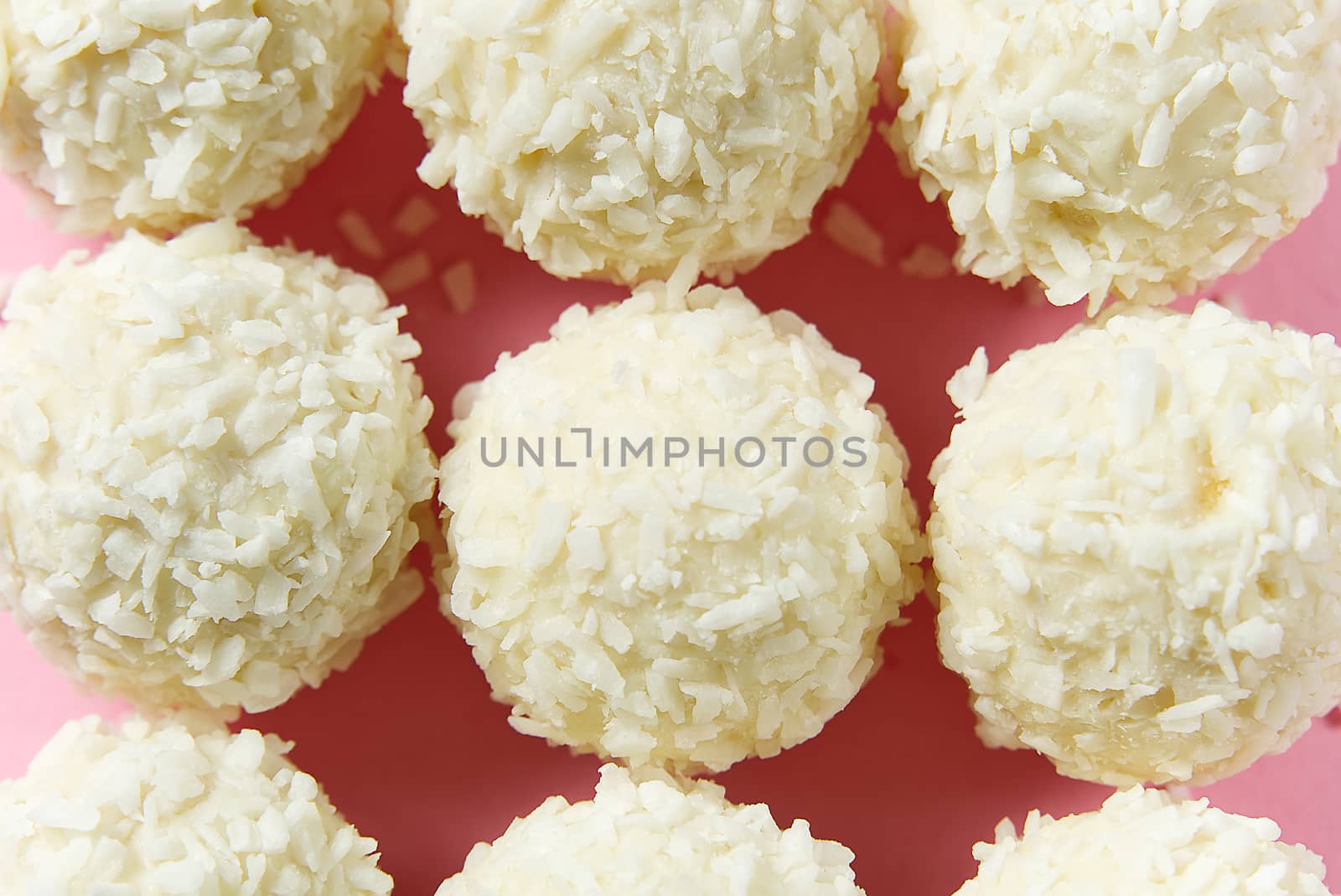 Closeup Homemade White Candy With Coconut Topping On pink Background. by PhotoTime