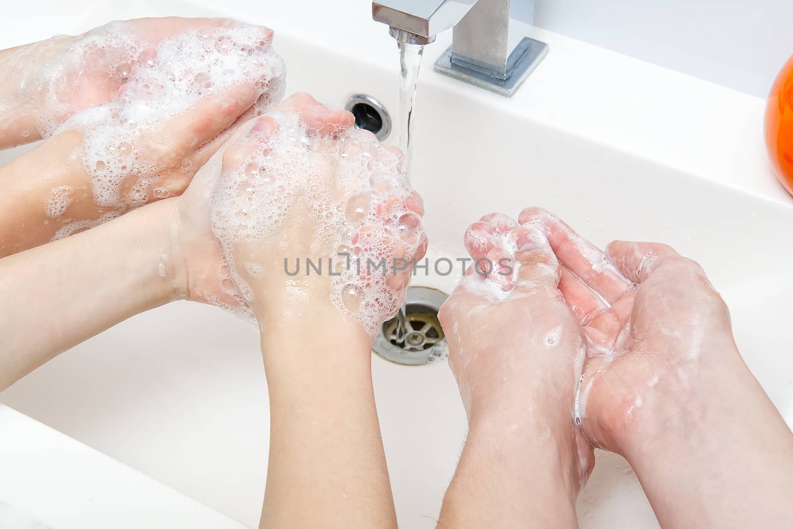 Childrens washing hands with soap under the crane with water. close-up. personal hygiene concept by PhotoTime