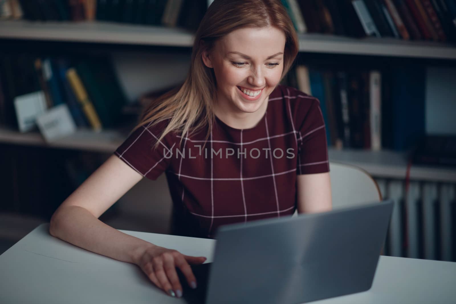 Young beautiful blond student girl with laptop by primipil