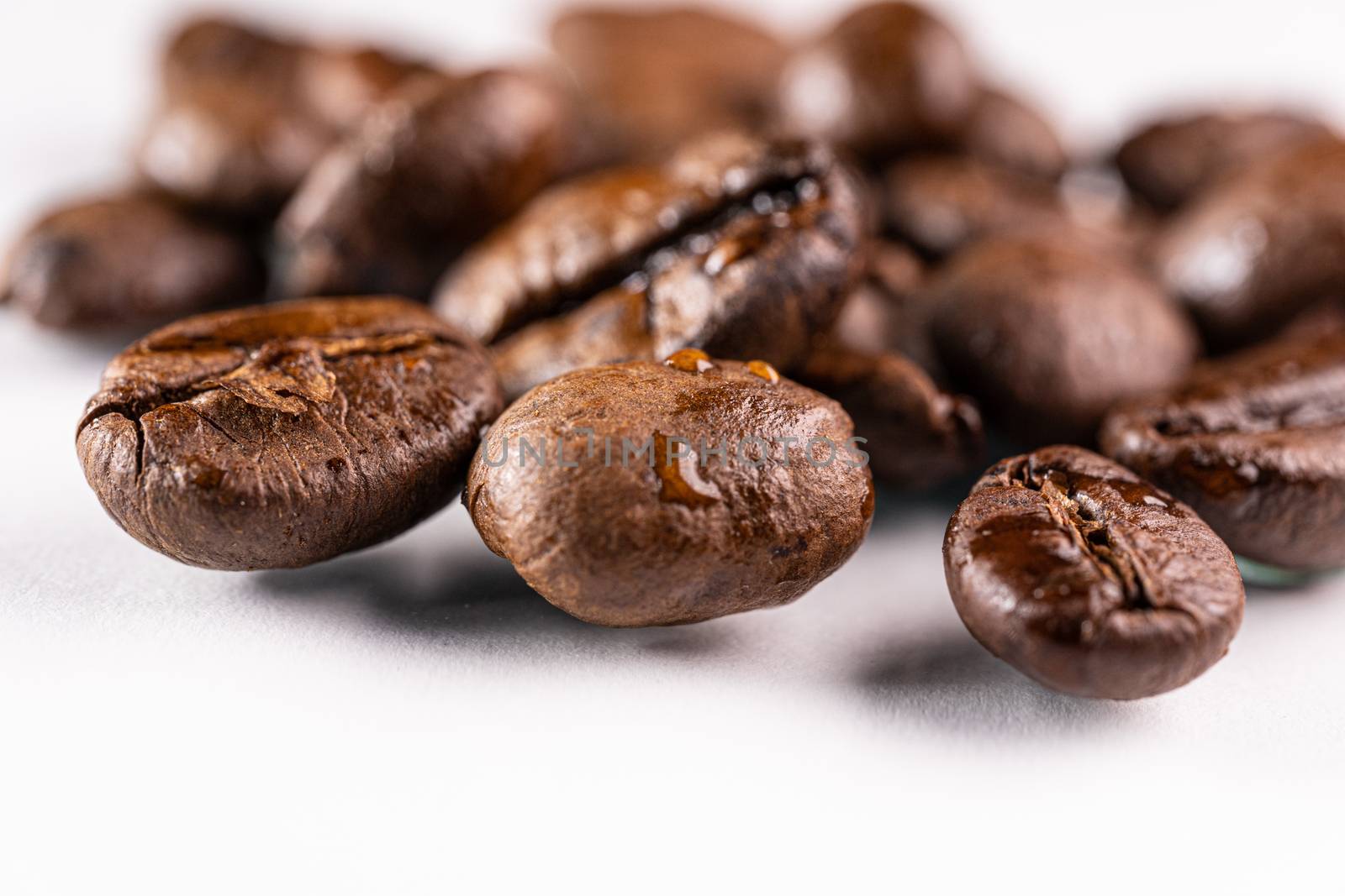 Macro view of roasted coffee beans on white background