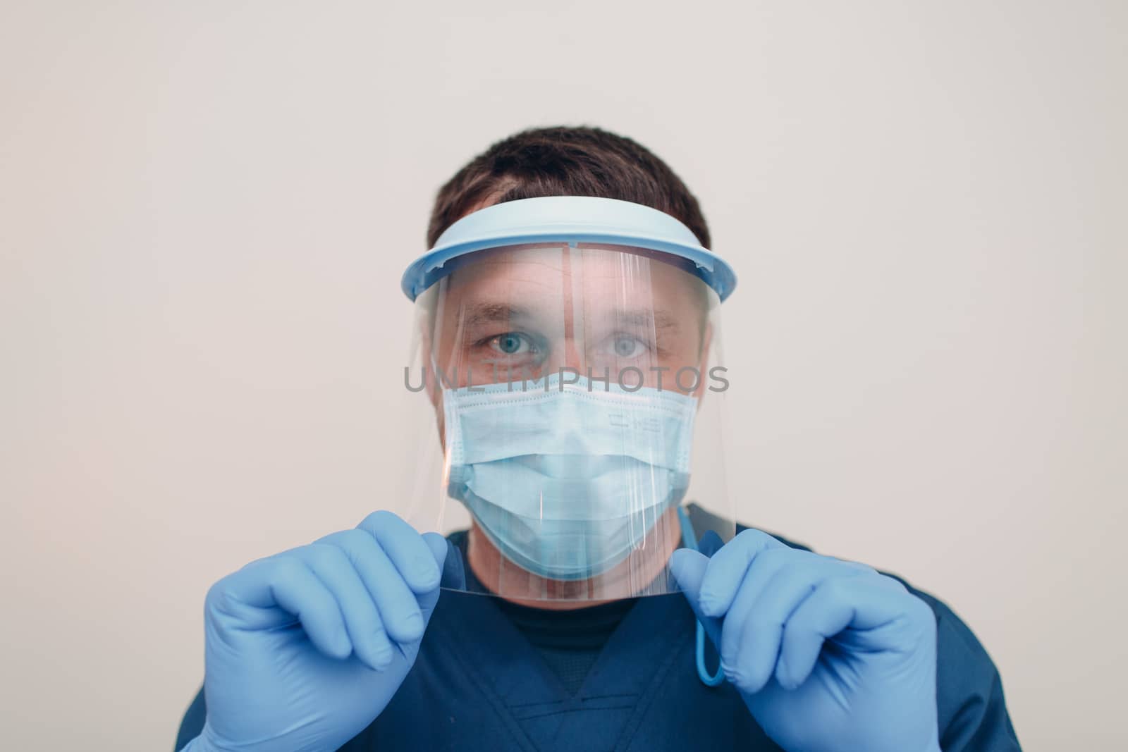 Man in face medical surgical mask with transparent shield mask and gloves.