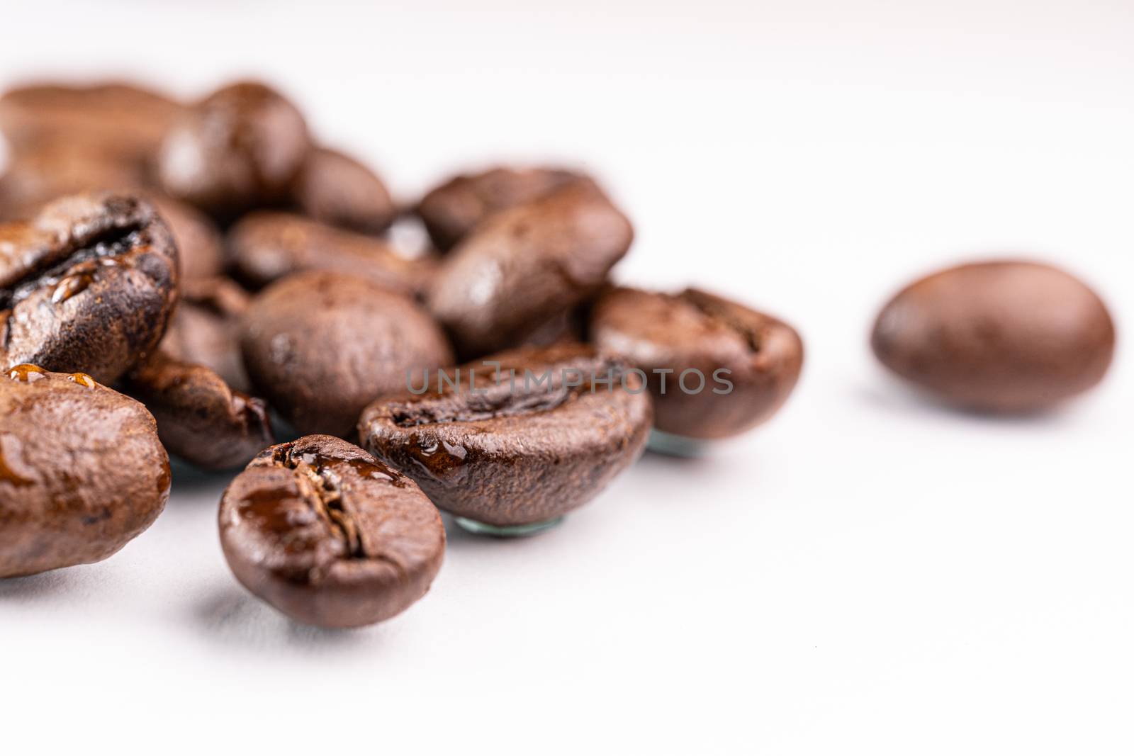 Macro view of roasted coffee beans on white background