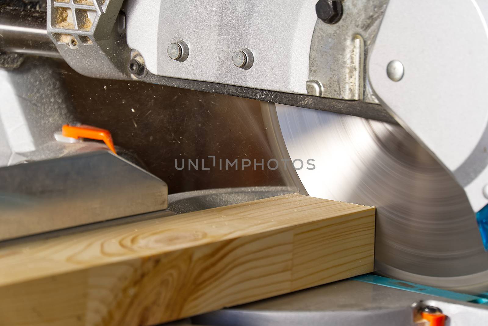 Closeup of professional cabinet makers working with electric circular saw at woodworking workshop. Skilled carpenter cutting wooden board with circular saw. Wood material production. Lumber factory by PhotoTime