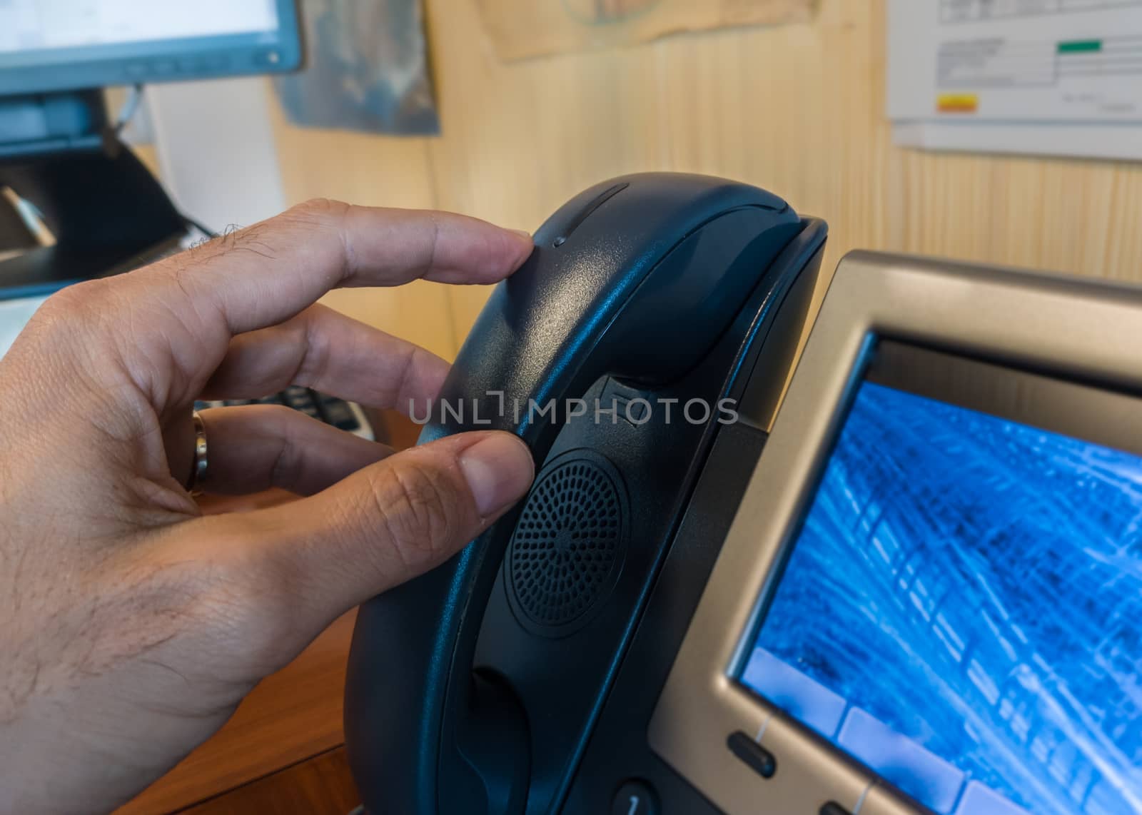 Close up Businessman calling through an IP Telephone at workplace.