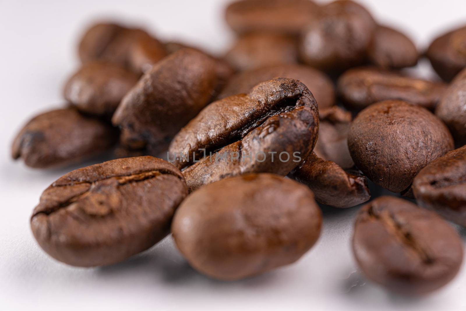 Macro view of roasted coffee beans on white background