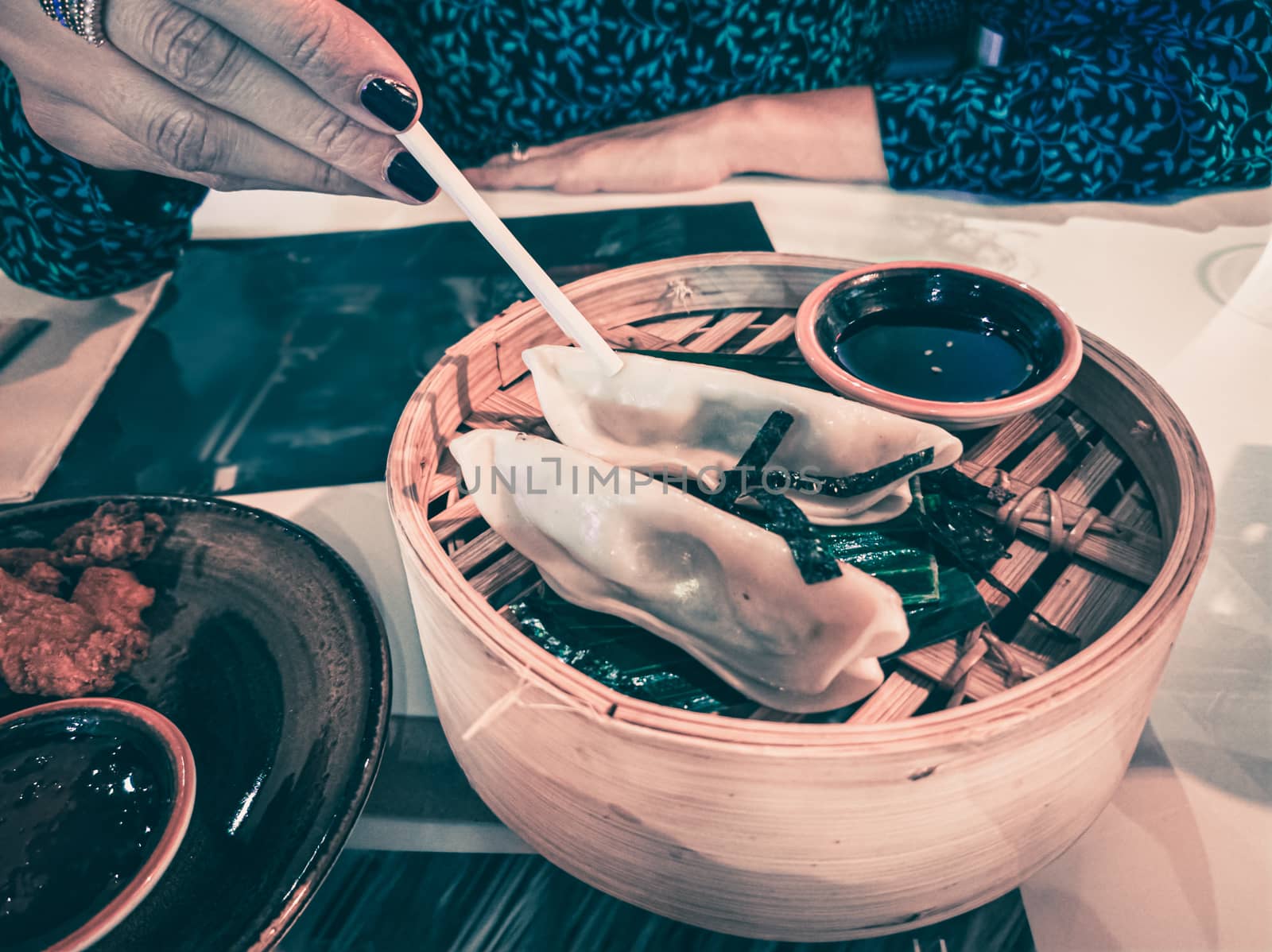 Woman hand holding japaneese gyoza with chopsticks. Japanese or asian restaurant and food. Vintage look