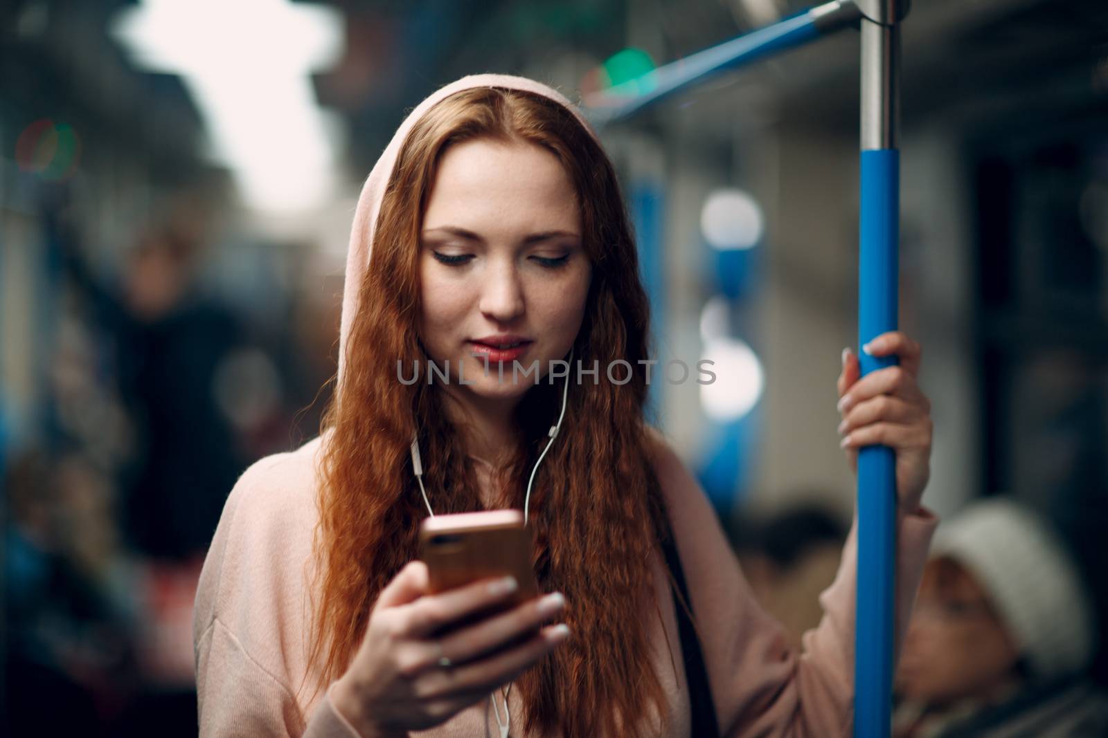 Young woman with mobile phone in subway. Wi fi in metro concept.