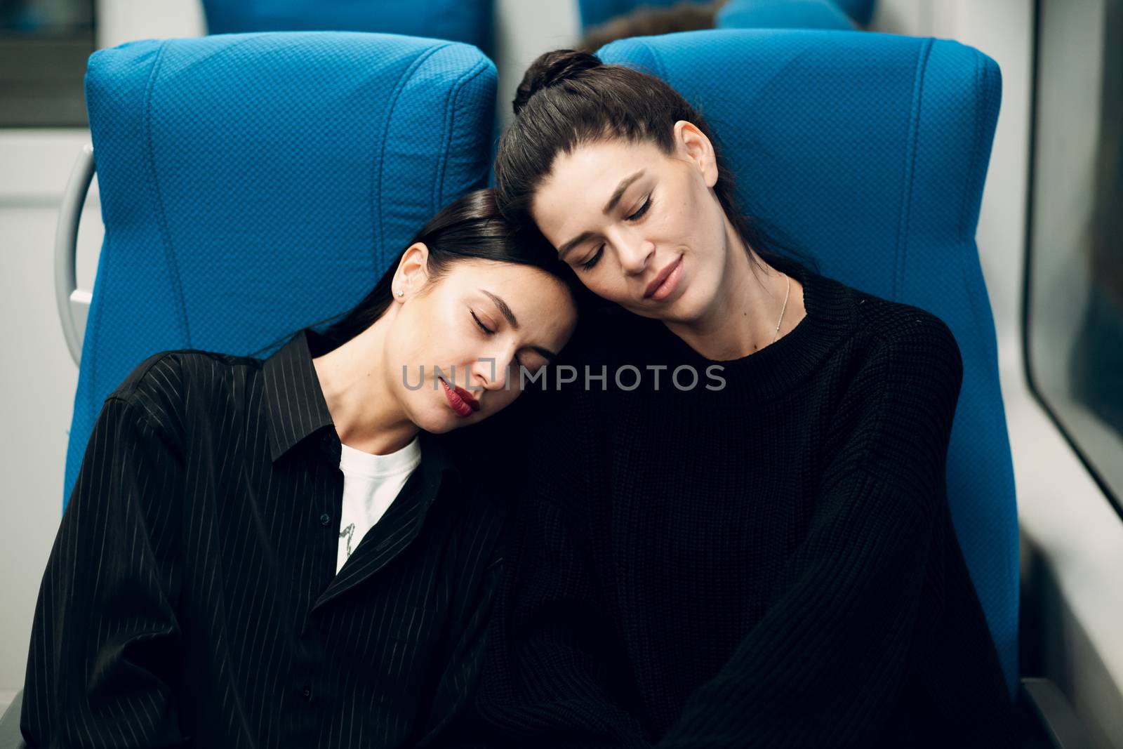 Two young women sleeping in  train