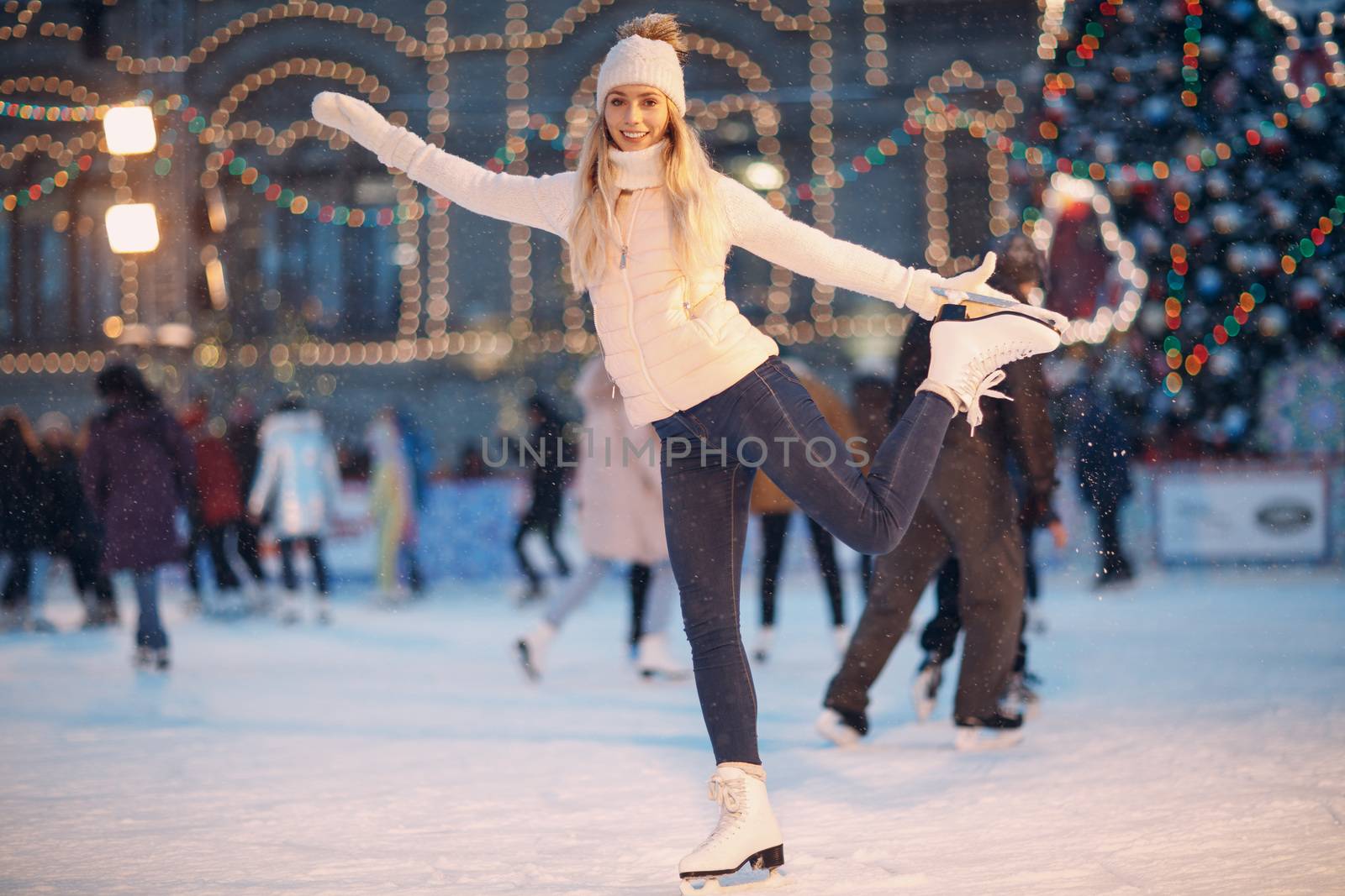 Young smiling woman with skates on the ice rink by primipil