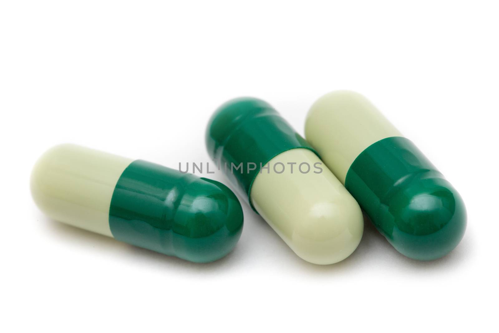 Green capsules closeup isolated on white background by primipil