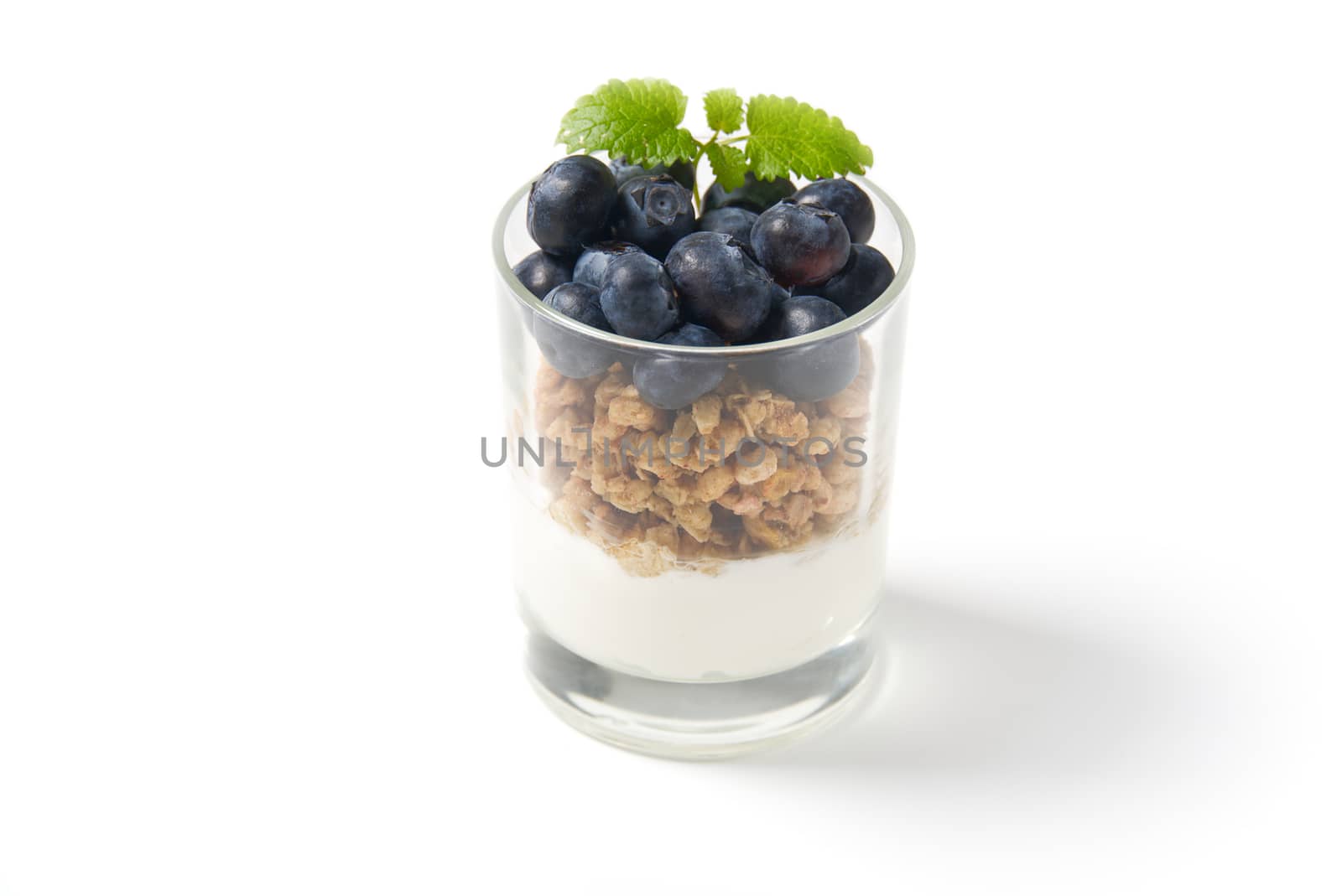muesli dessert with yogurt and blueberry in a glass over white background. Granola in glass with berries and yogurt. by PhotoTime