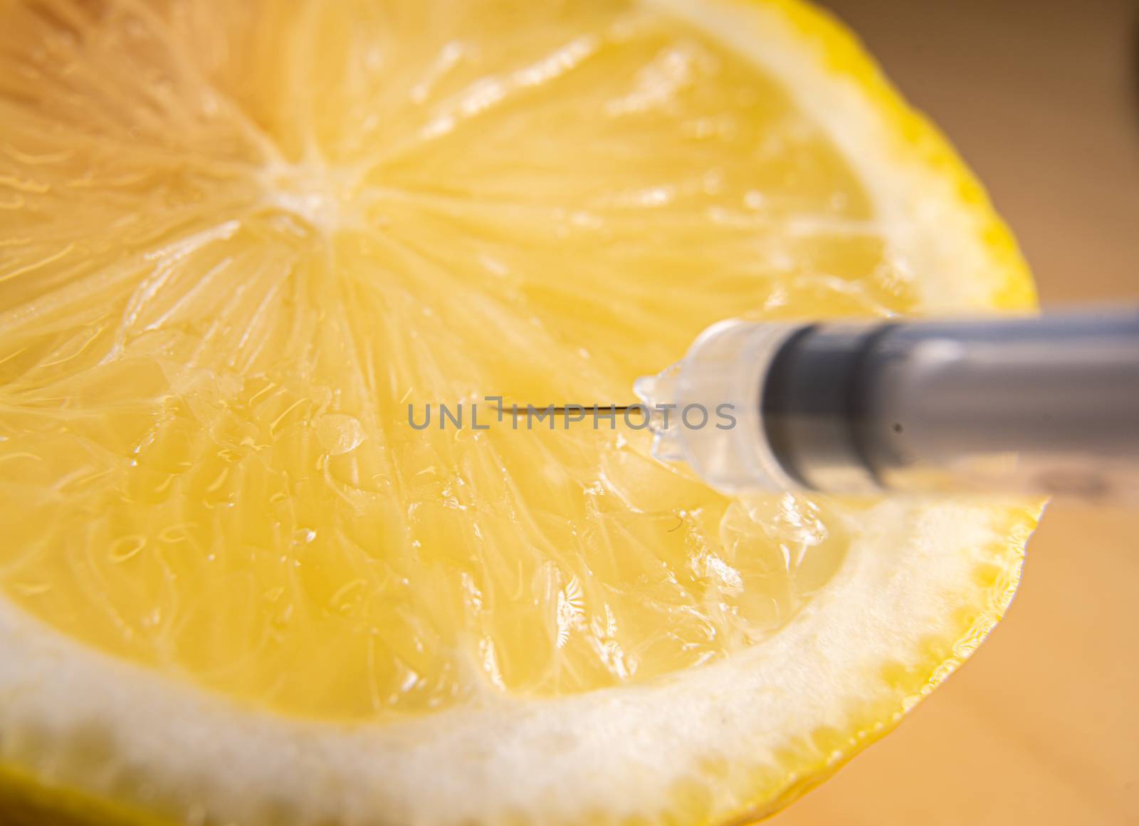 Syringes or needles extracting vitamin C from lemon. by tanaonte