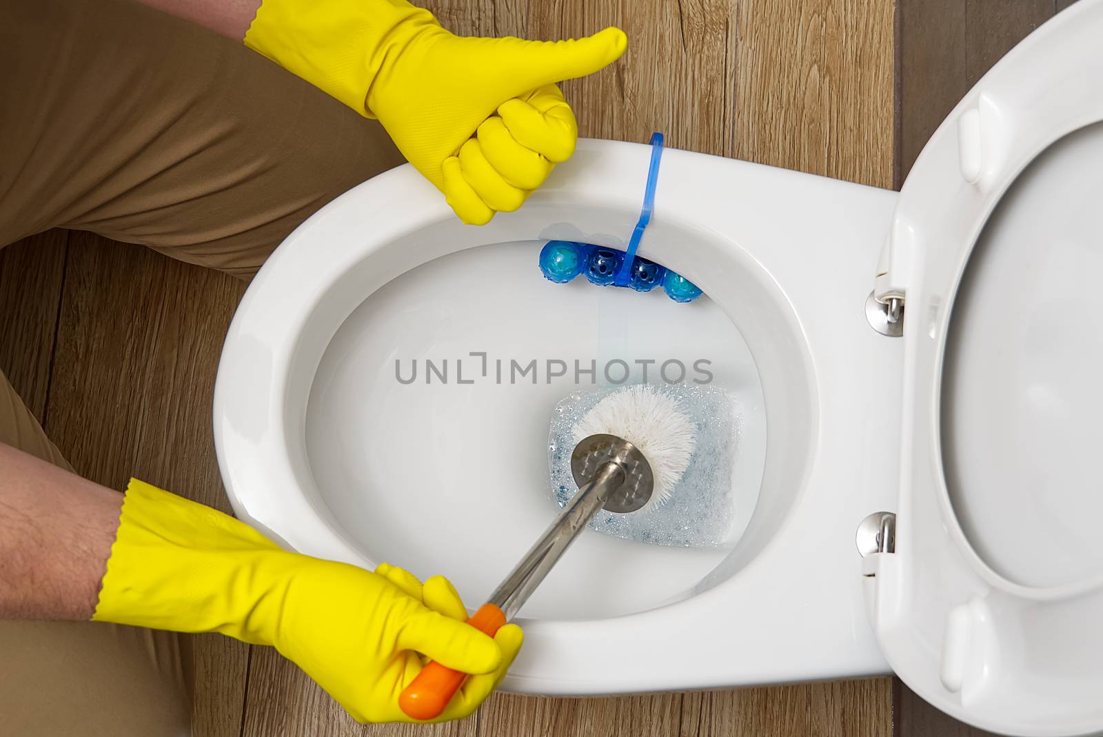 man cleaning wc. Housekeeper as a cleaning man at the toilet. Brush up Toilet for cleanliness and hygiene. cleaning toilet bowl. Cleaning service concept by PhotoTime