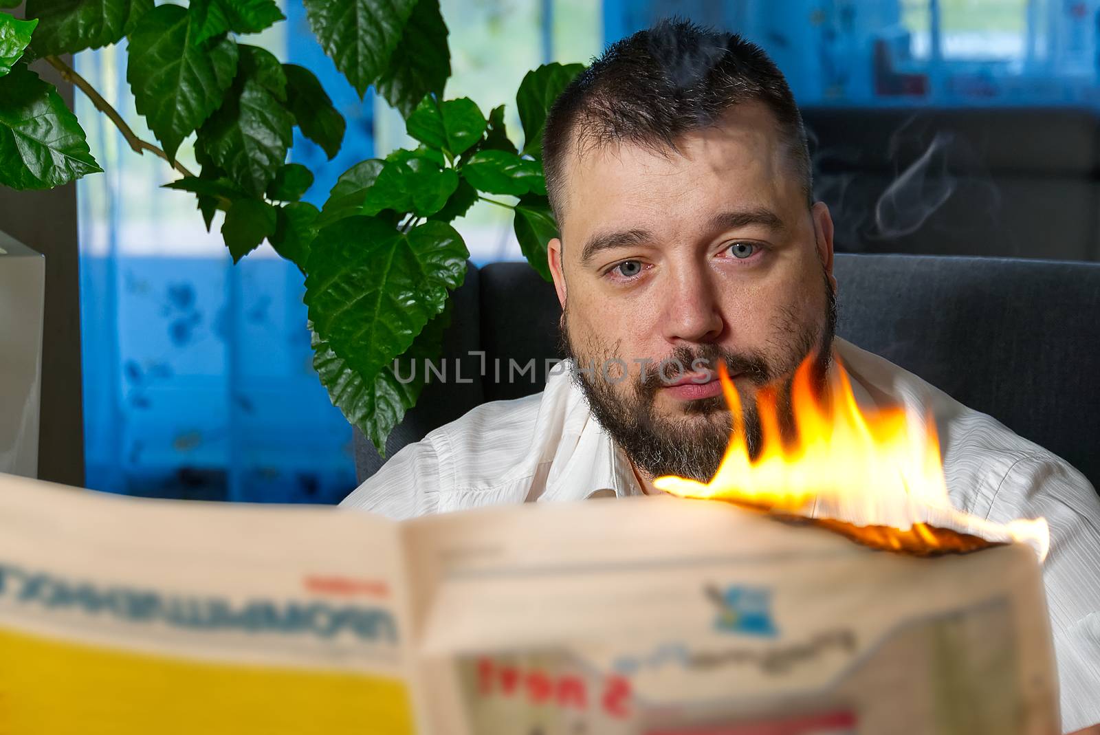 Man reading news in burning newspaper. Burning magazine, newspaper in mae hands. fake news, breaking news concept.