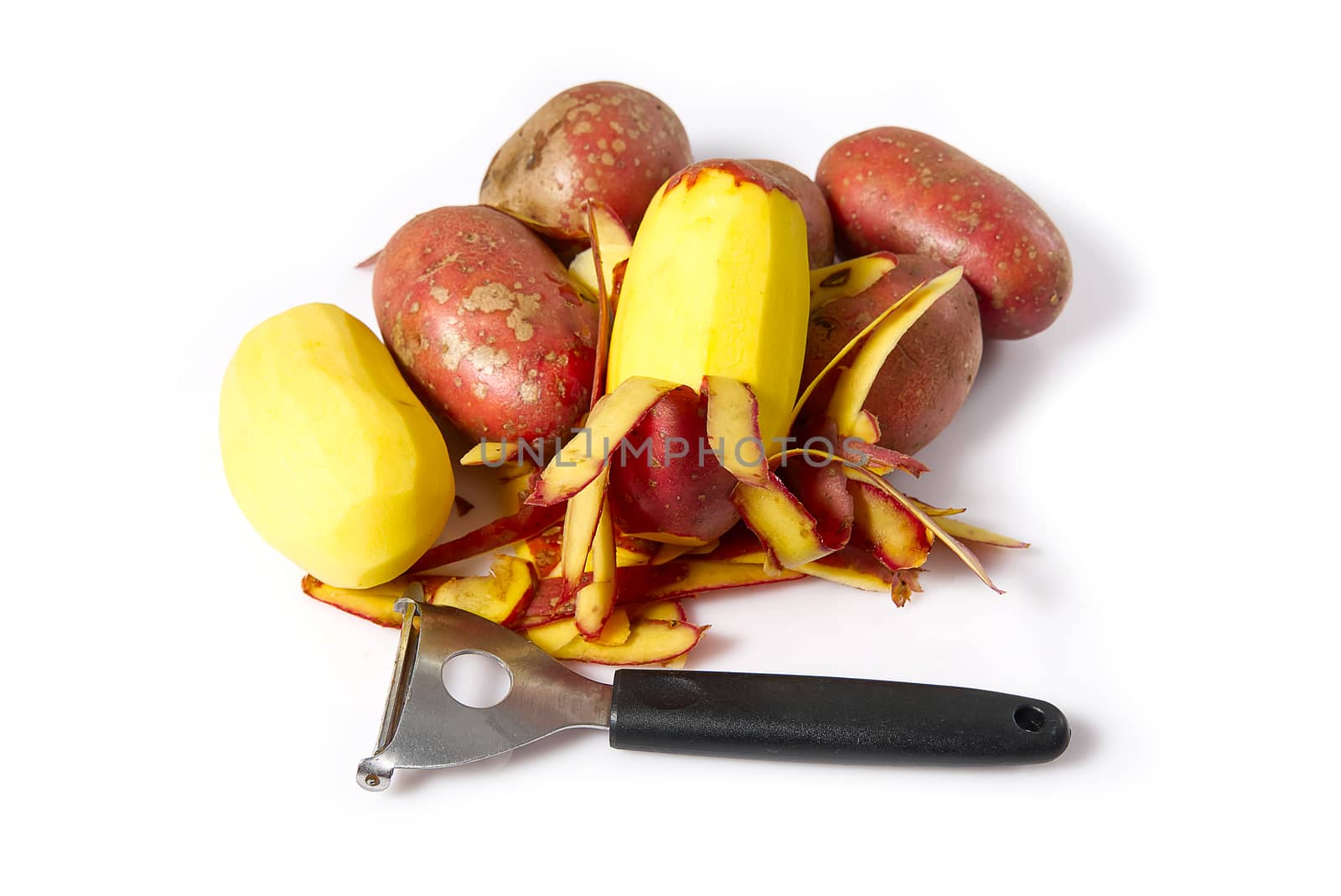 a pile of unpeeled potatoes and black potatoes peeling, white background, object isolated. potato and peeler by PhotoTime