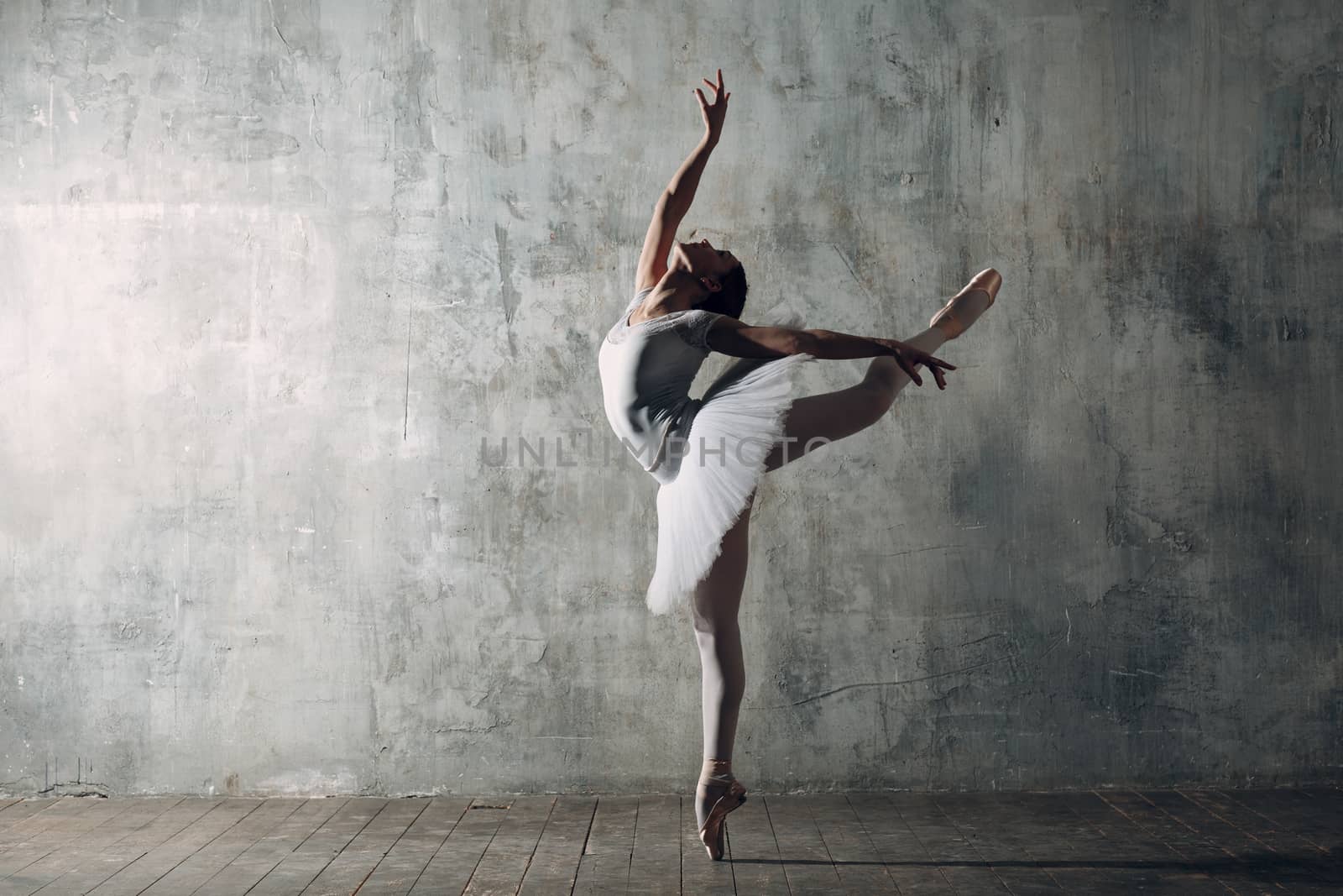 Ballerina female. Young beautiful woman ballet dancer, dressed in professional outfit, pointe shoes and white tutu.