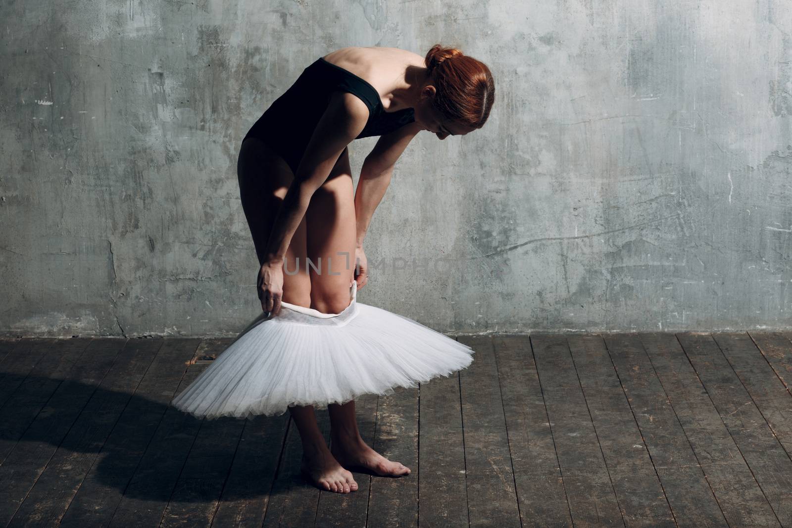 Ballerina putting on white tutu. Young beautiful woman ballet dancer,