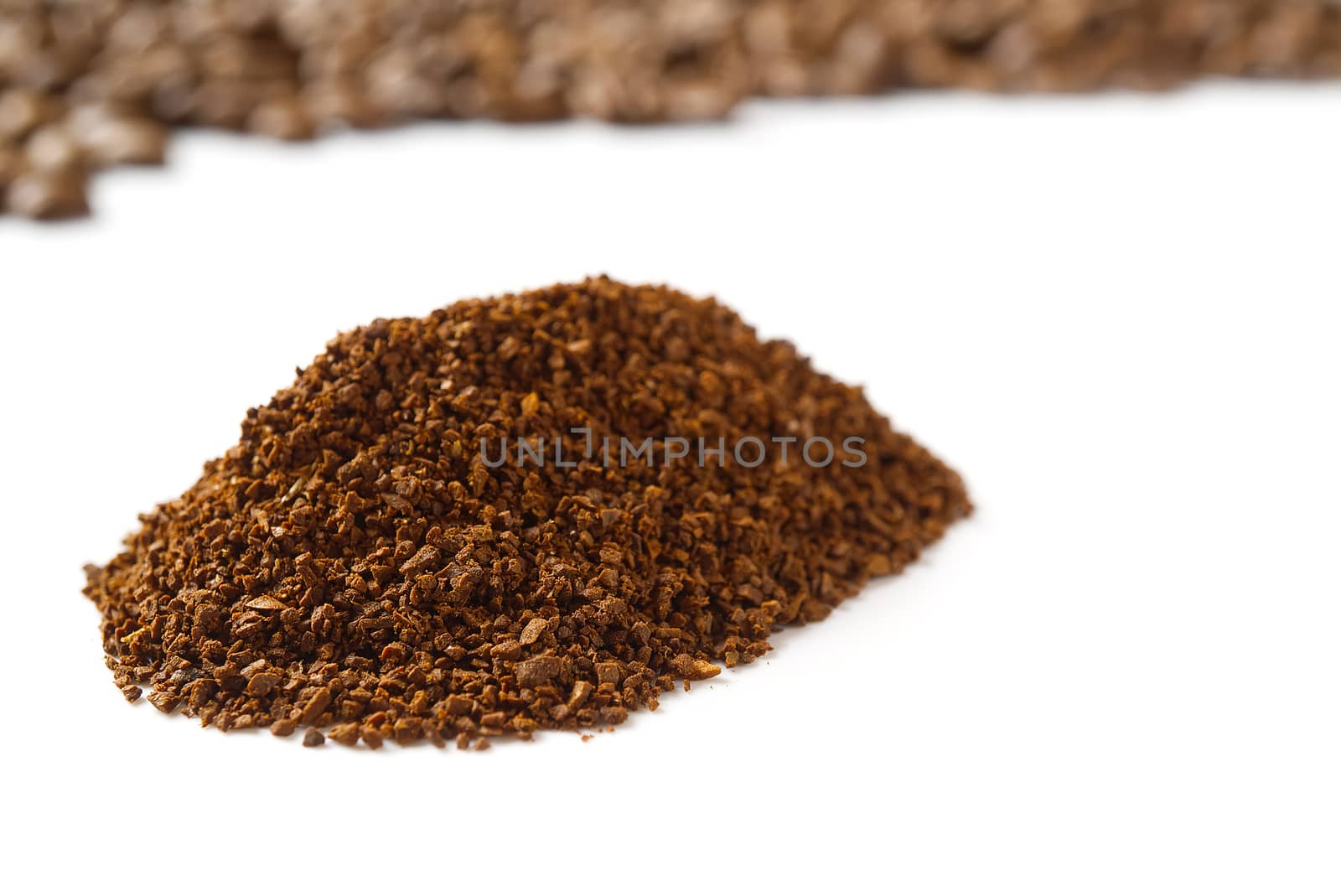 Pile of the ground coffee flakes isolated over the white background. pile of melted coffee.