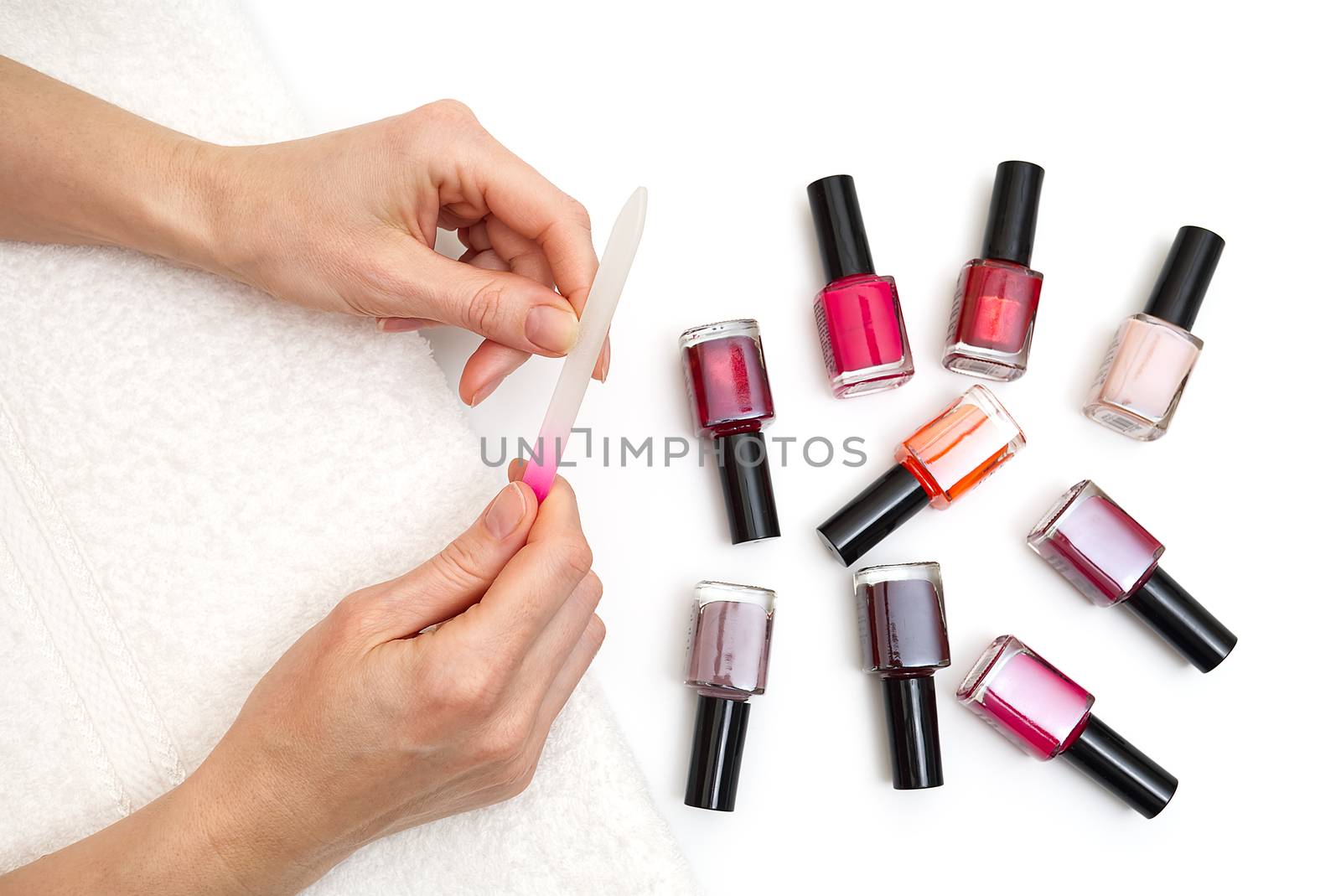 woman filing her finger at home. female polishes her nails to herself. manicure procedures yourself at home. by PhotoTime