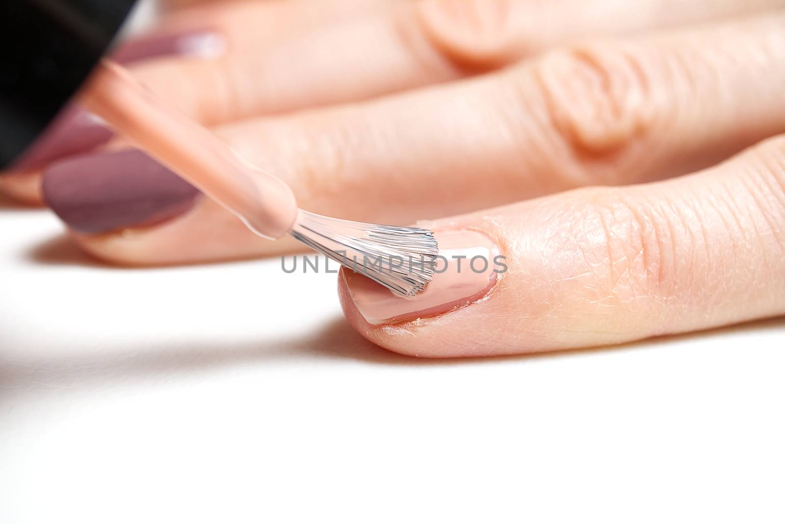 Woman applying nail polish. Beautiful nails. Woman applying polish on nails at home. Pastel nail polish on fingernail. Beauty treatment and hand care concept. manicure procedures yourself at home.