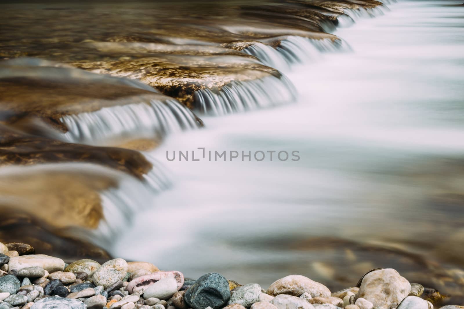 Small waterfall in a riveer with blurred water flow from long exposure.