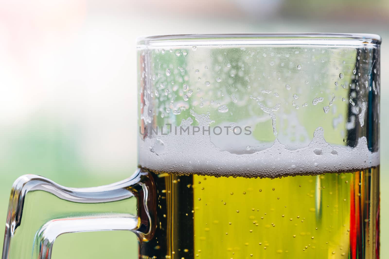 Close up of a glass of beer with foam on top.