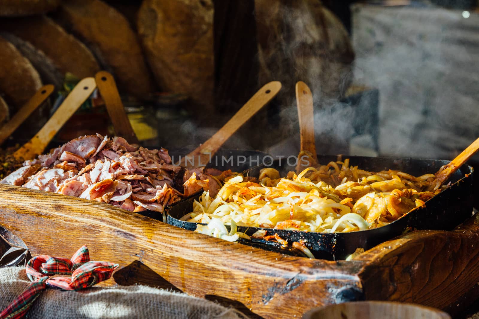 Krakow Christmas market stall serving traditional slices of bread with grilled meat, onions and sauce.