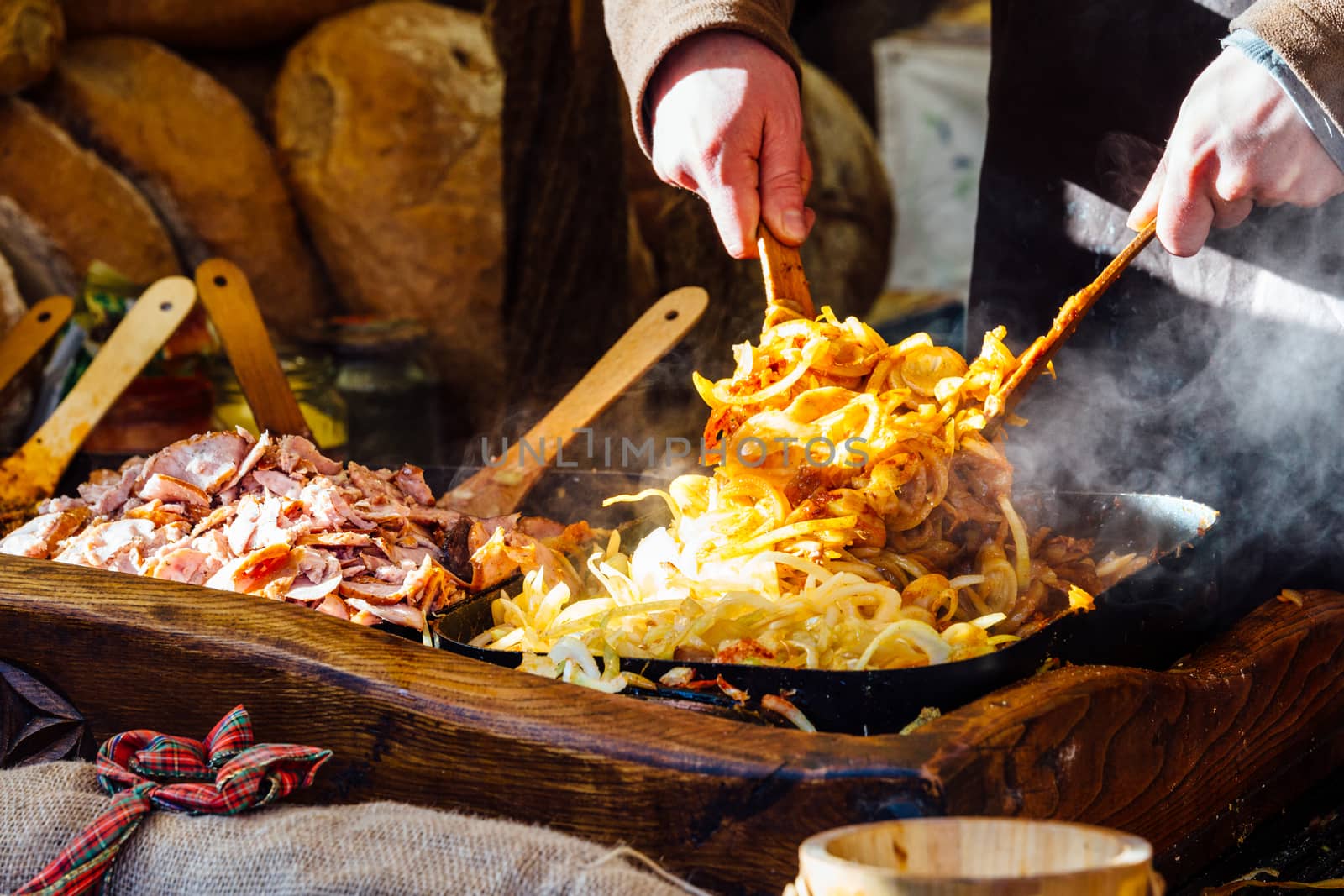 Krakow Christmas market stall serving traditional slices of bread with grilled meat, onions and sauce.