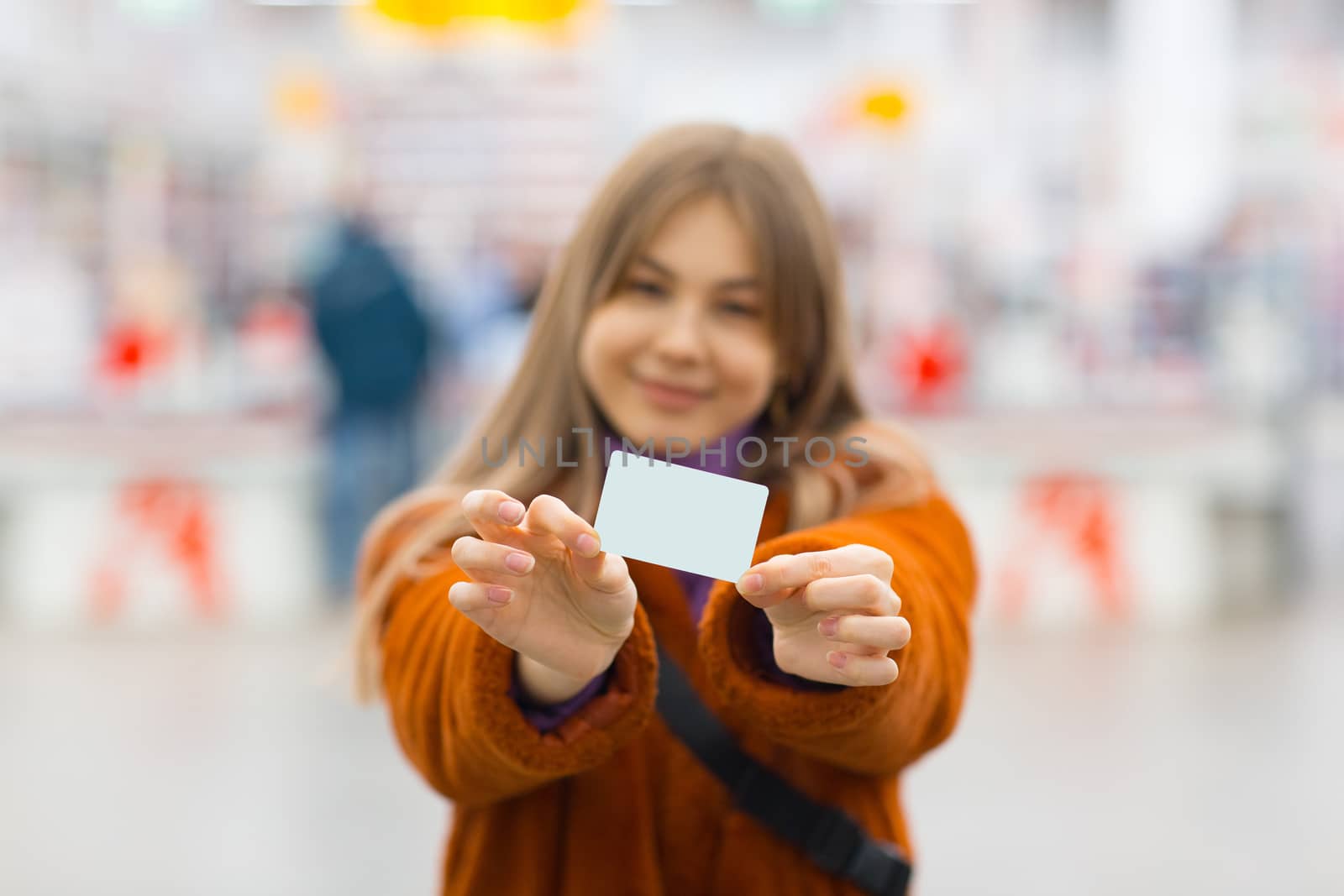 Young woman holds credit card in hands by primipil